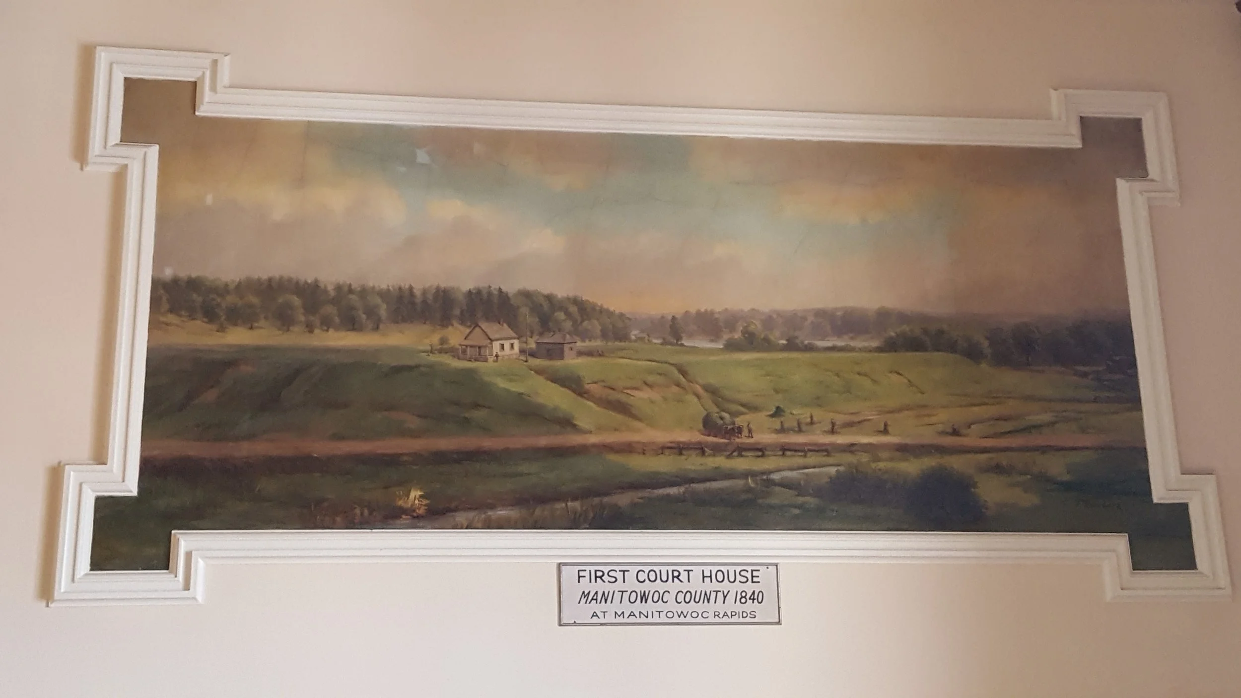 The First Court House and Jail at Manitowoc Rapids mural, painted by Franz Rohrbeck in 1912, is located in the west staircase at the Manitowoc County Court House.