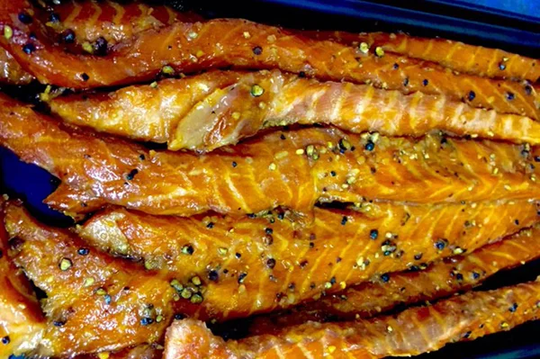 CANDIED GARLIC PEPPERED STRIPS Full strips of fresh salmon bellys sweeten similar to the candied salmon, but with a bite of heat from the garlic and peppercorn.