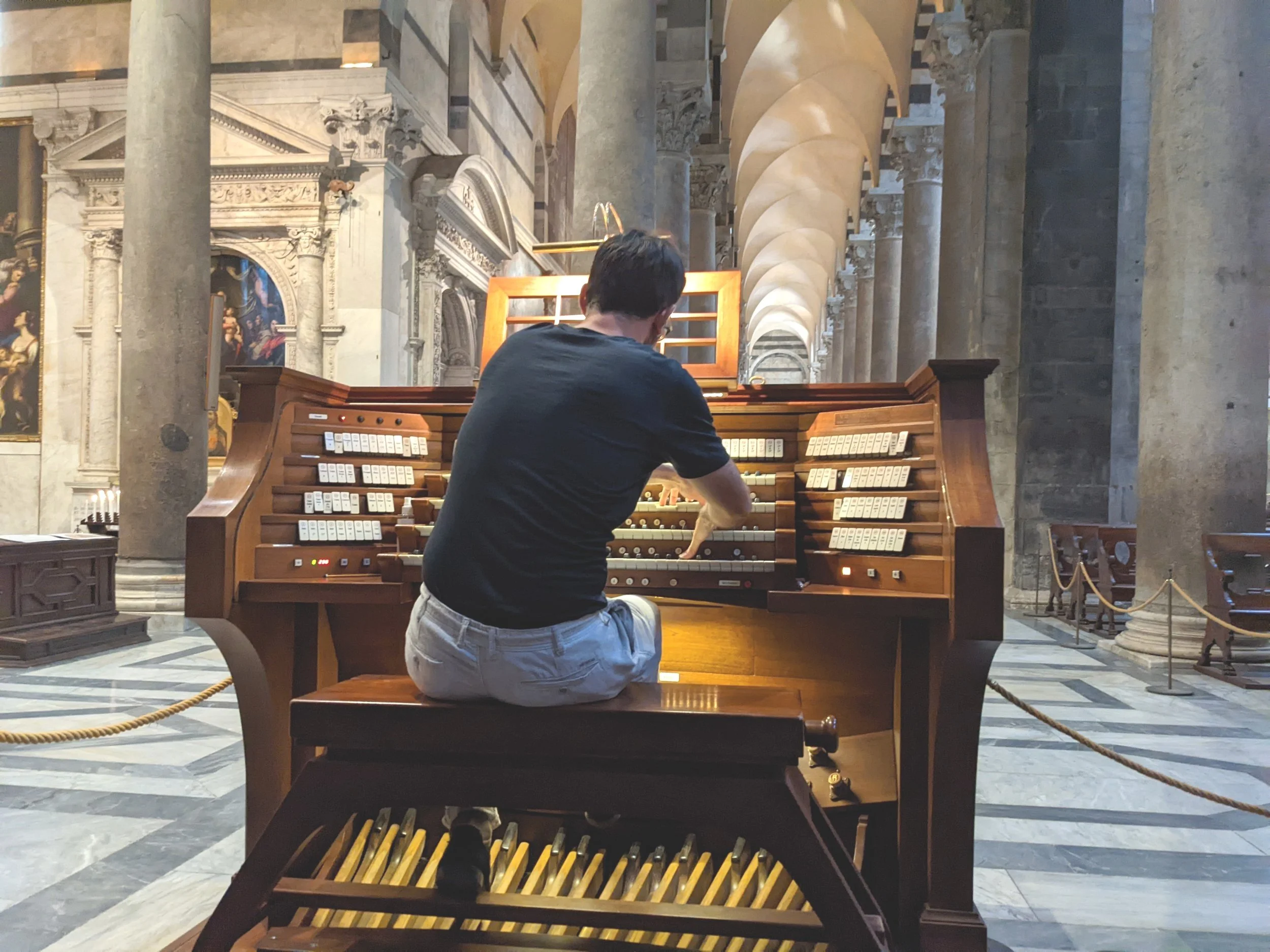 Rückansicht von Michael Schultheis am Spieltisch der Orgel im Dom zu Pisa. Dynamische Spielposition.