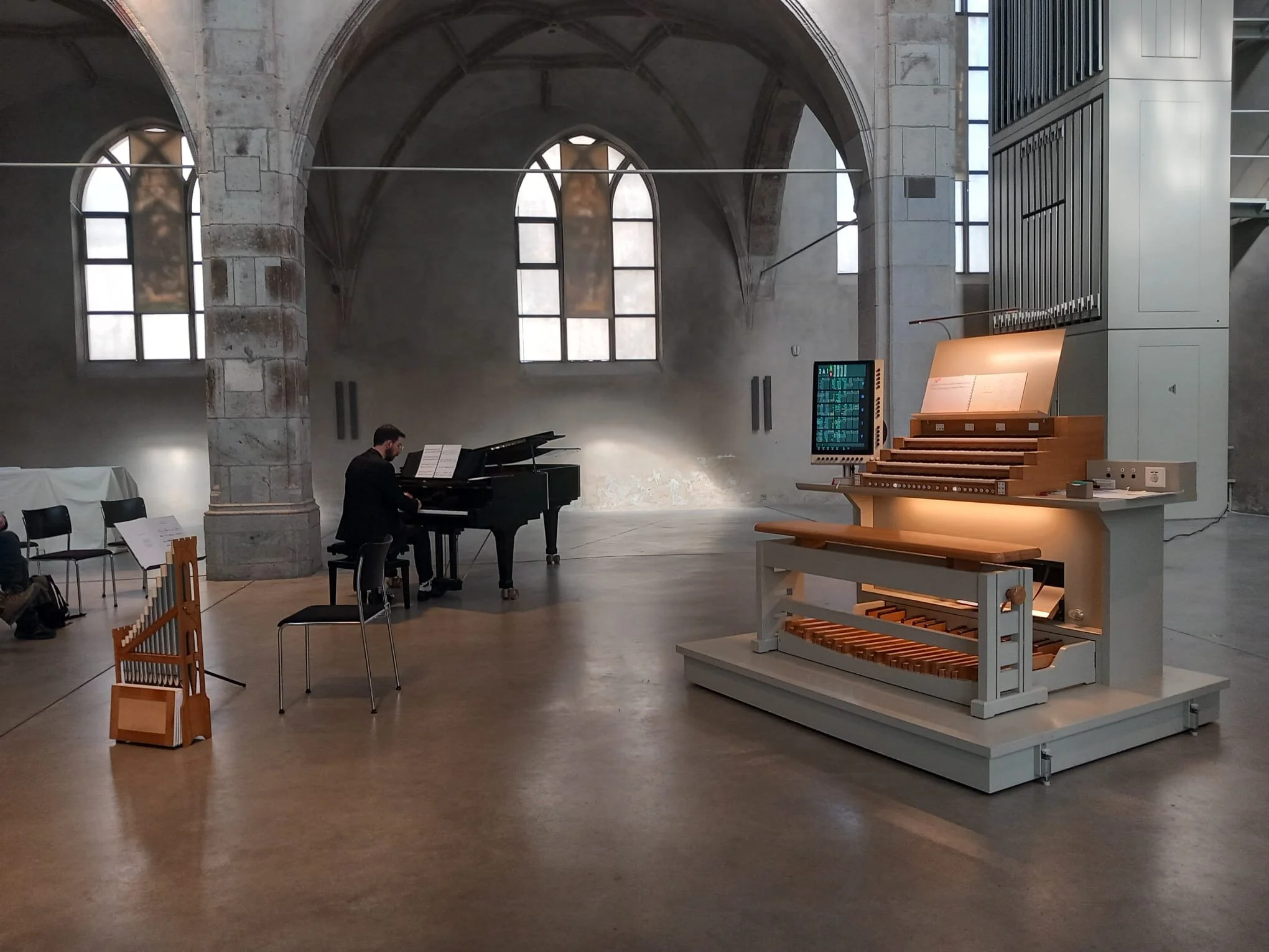 Innenraum der Kunststation St. Peter in Köln. Michael Schutheis am Klavier, daneben der fahrbare Orgelspieltisch.