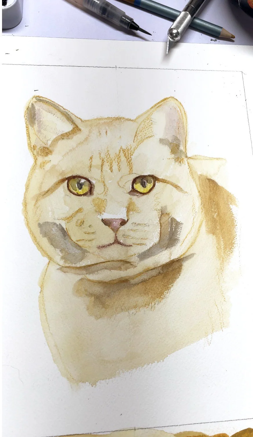 Watercolor painting of a cat with yellow eyes, light orange fur, and darker markings around the face, on white paper with art supplies around.