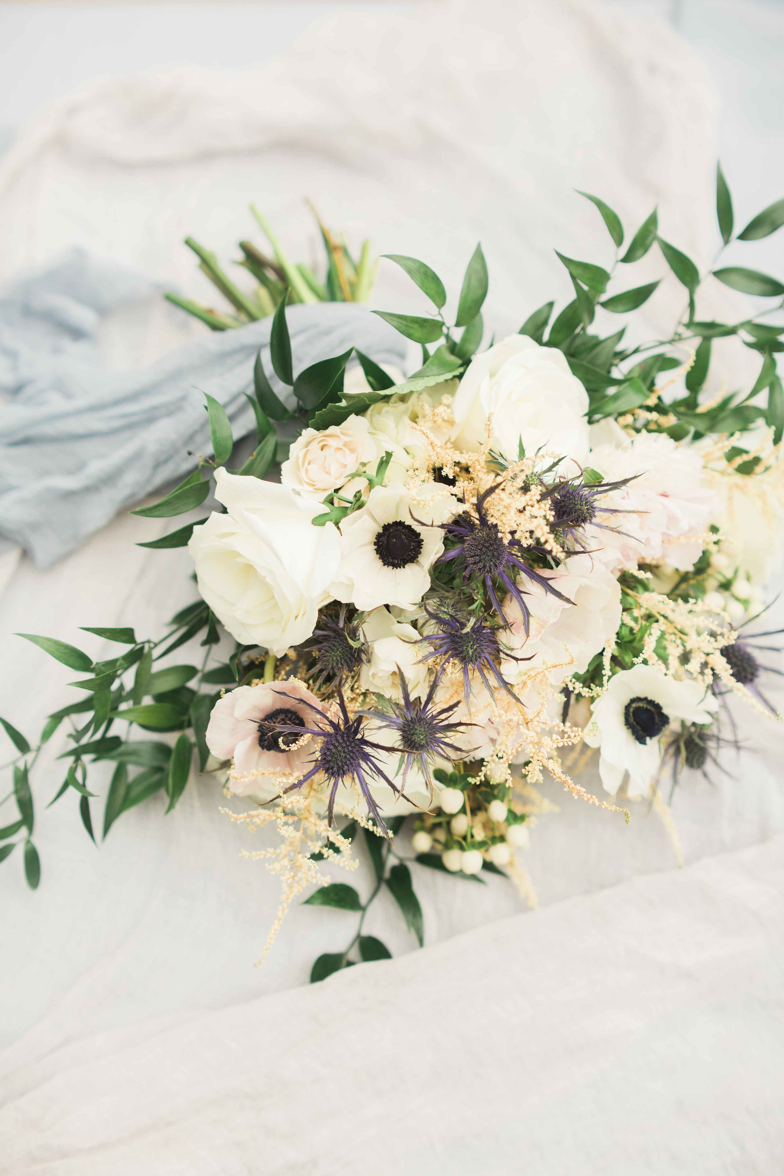white bouquet with dusty blue accents