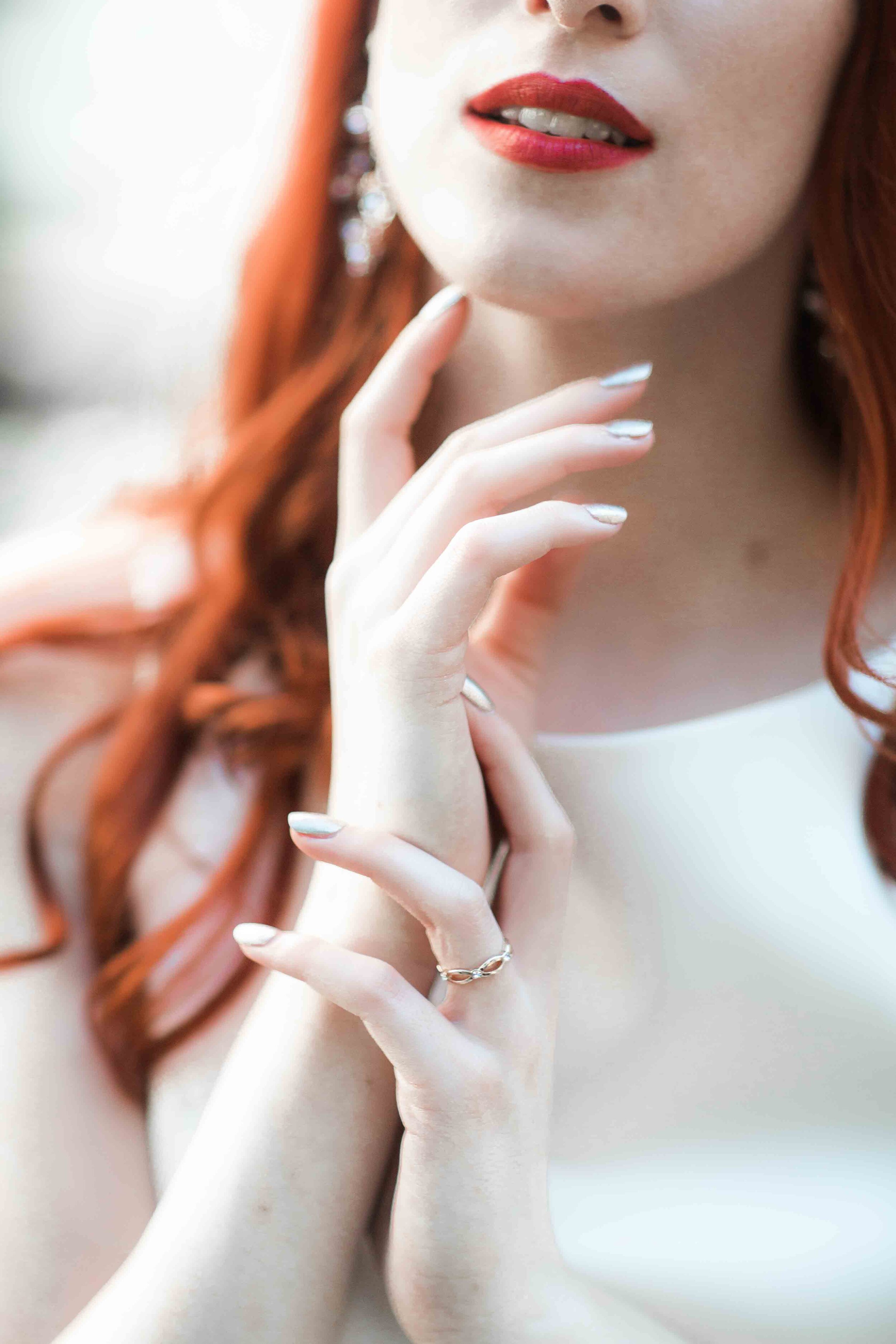 bride wearing red lips and soft pearl nude nails