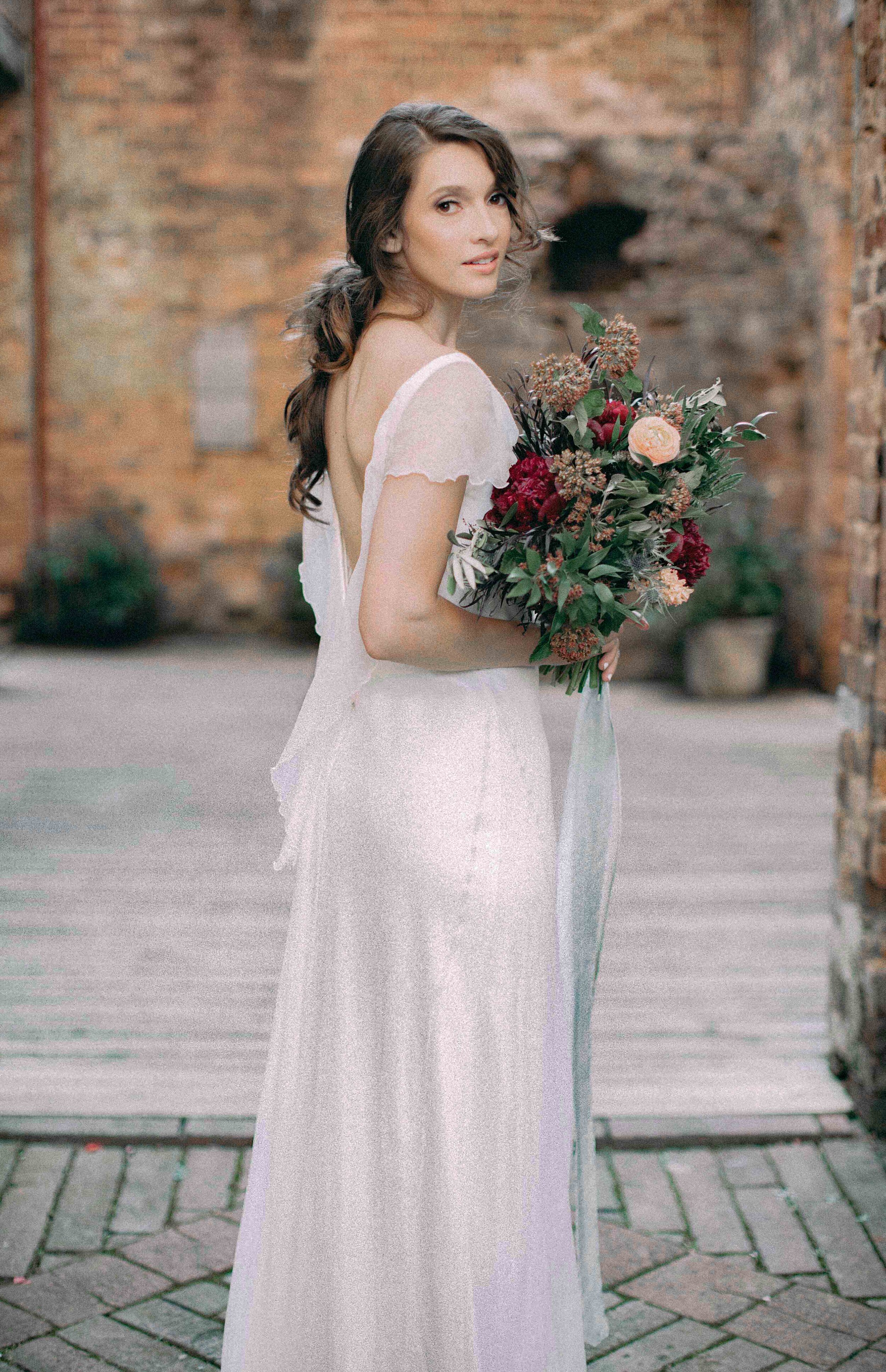 Dreamy boho bride with backless Chiffon wedding dress and wild flower bouquet