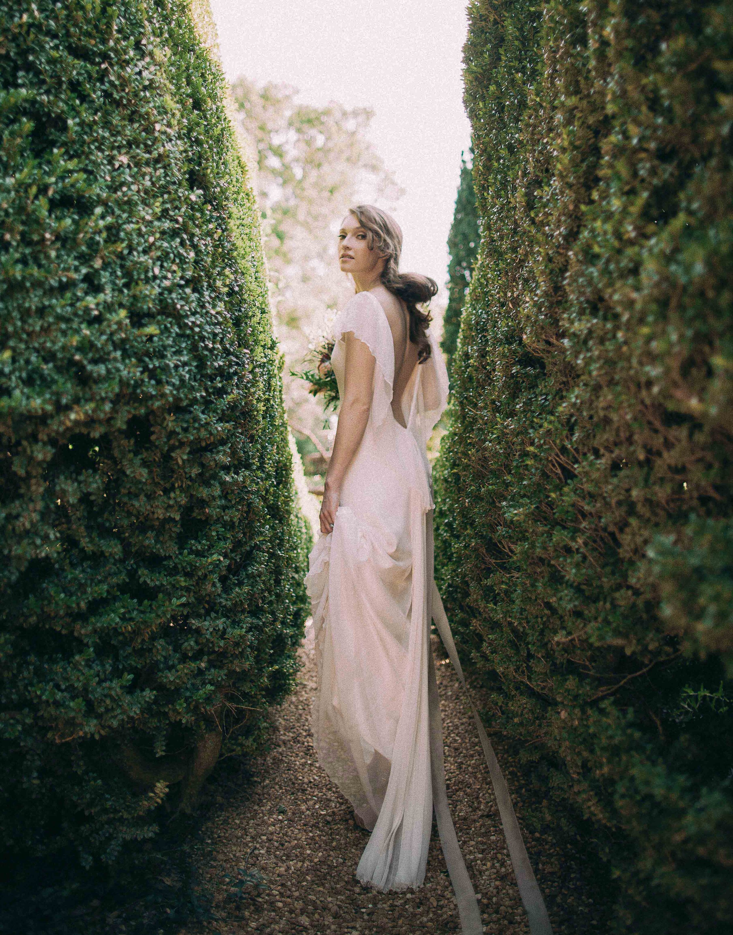 Romantic bride walking through gardens