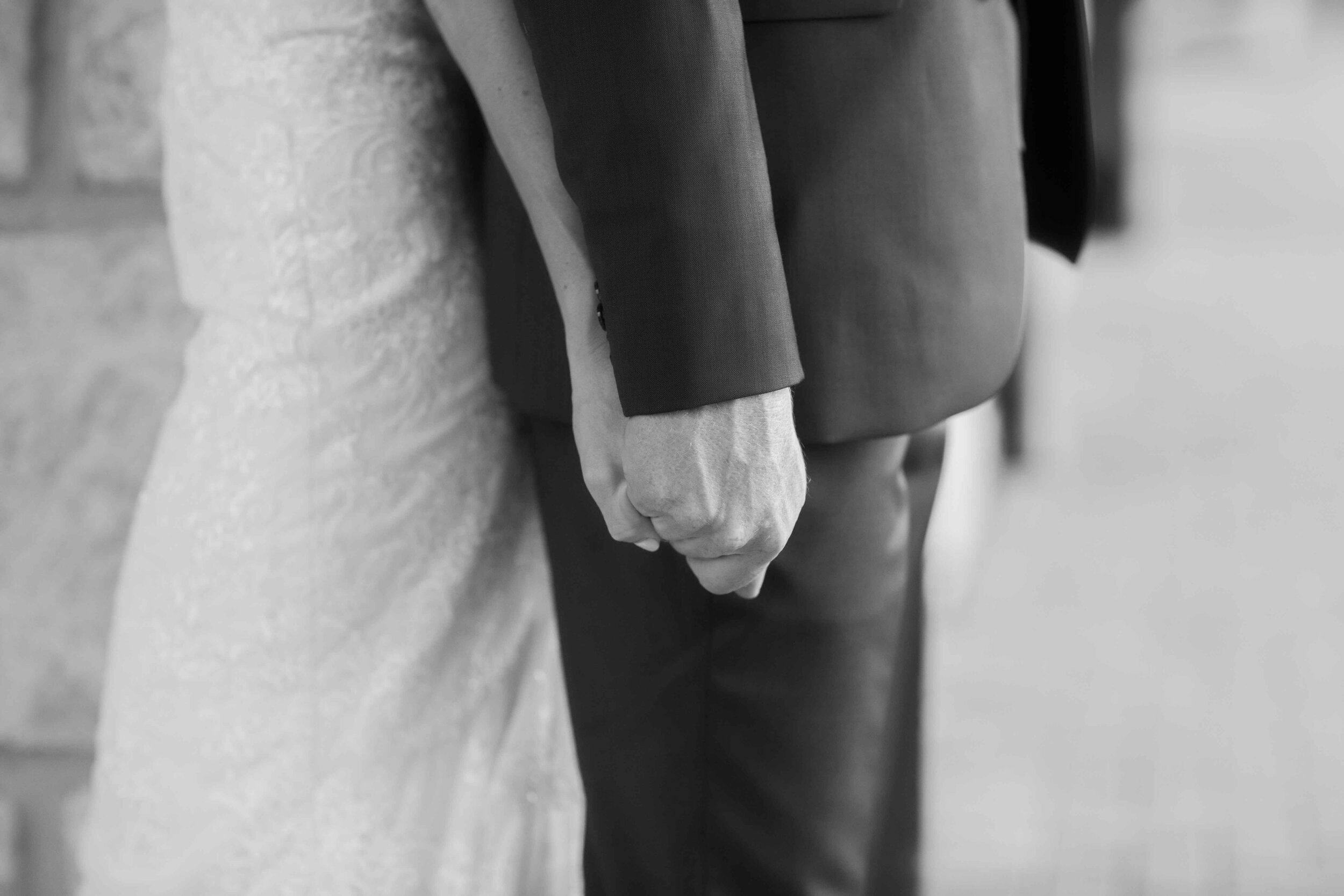 Bride and groom black and white hold hands