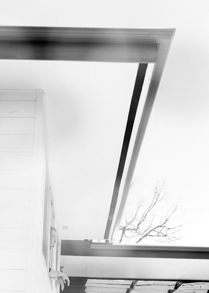 portrait of woman looking out window of modern home