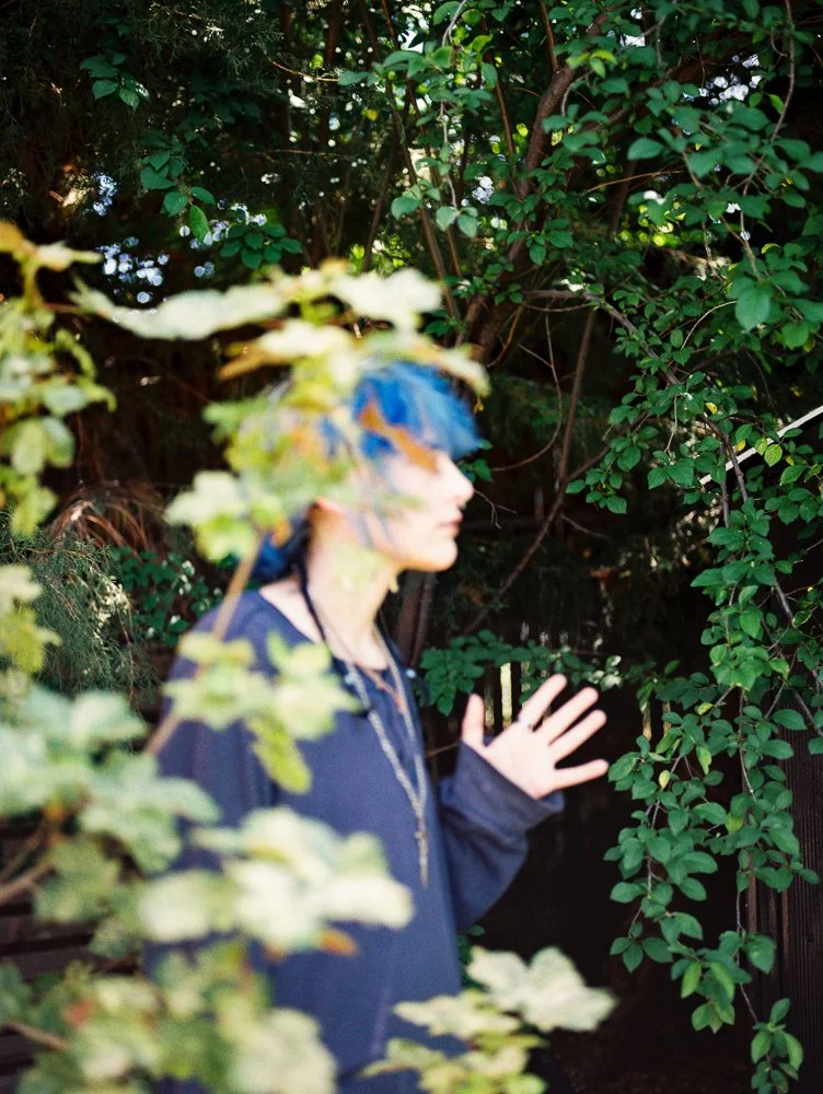 image of child in the trees with blue hair