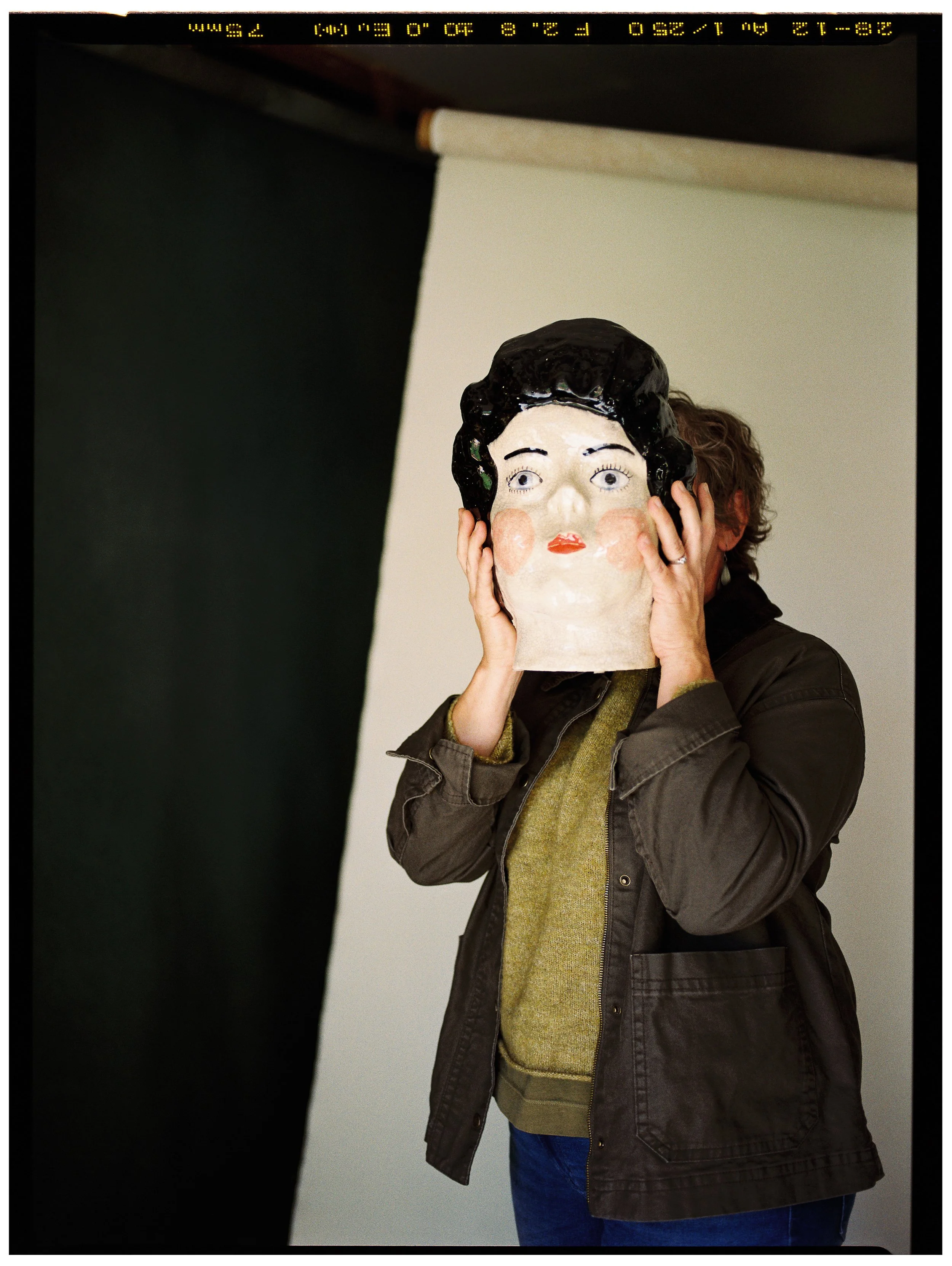 woman holds sculpture face film portrait