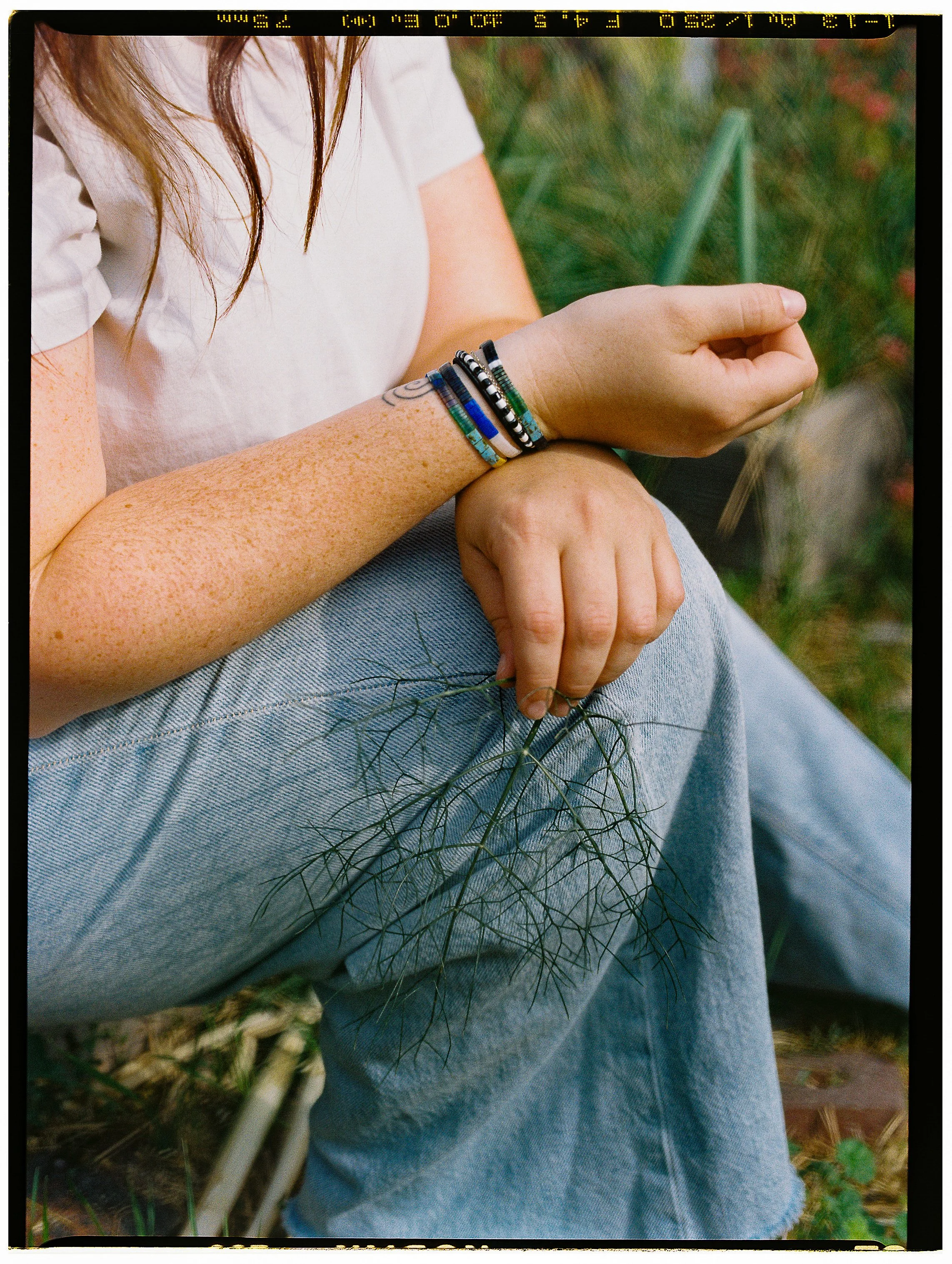 grainy film portrait of women with bracelets holding fennel