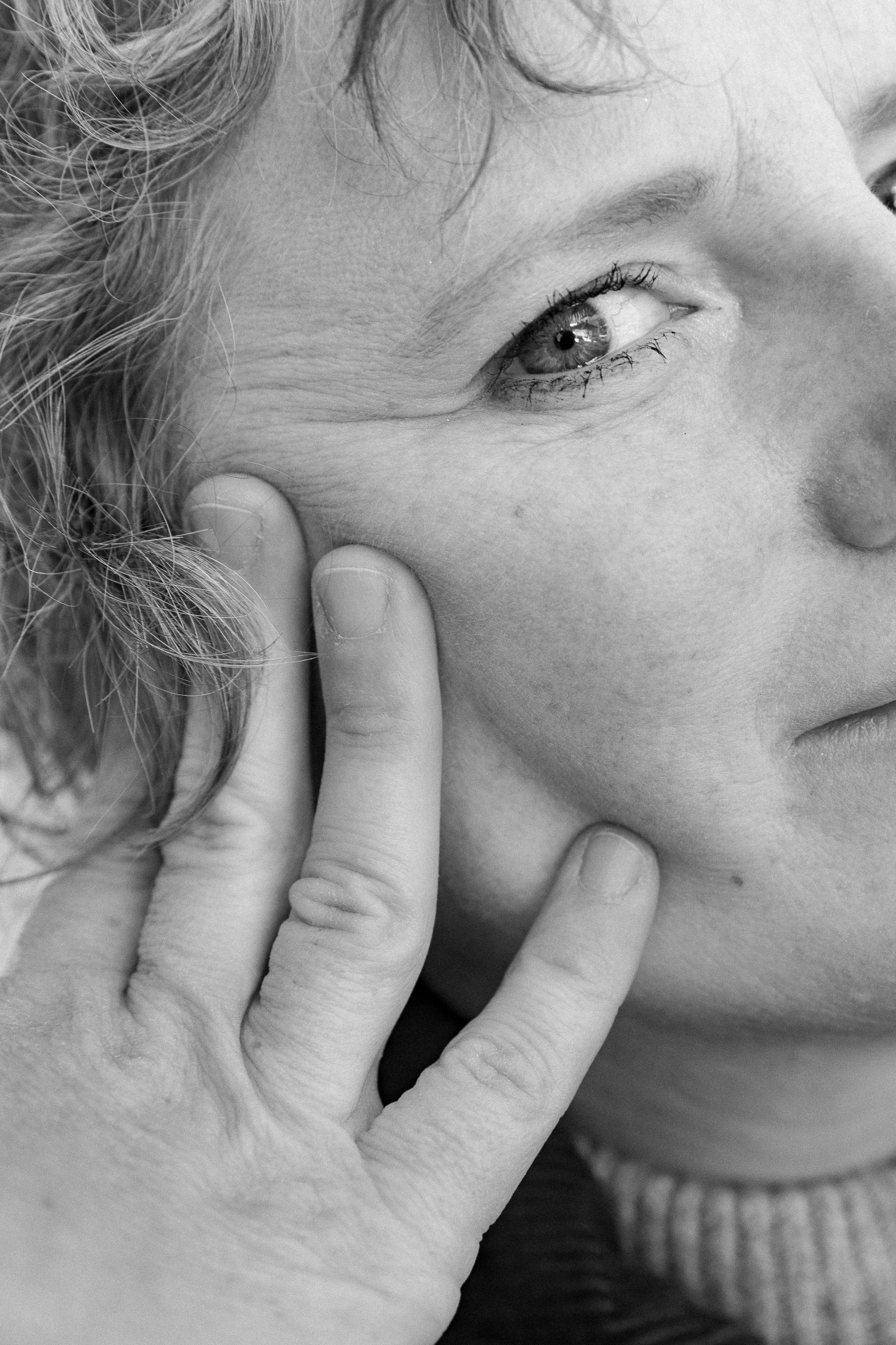 close up hand on face black and white portrait