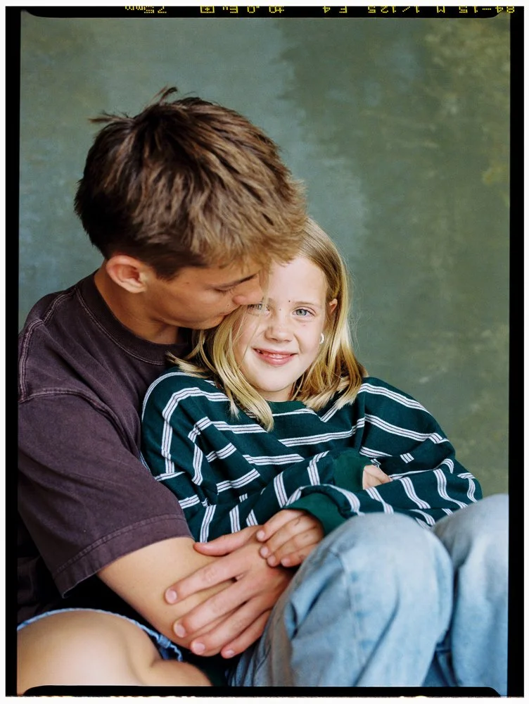 siblings pose in front of hand painted backdrop pop up studio