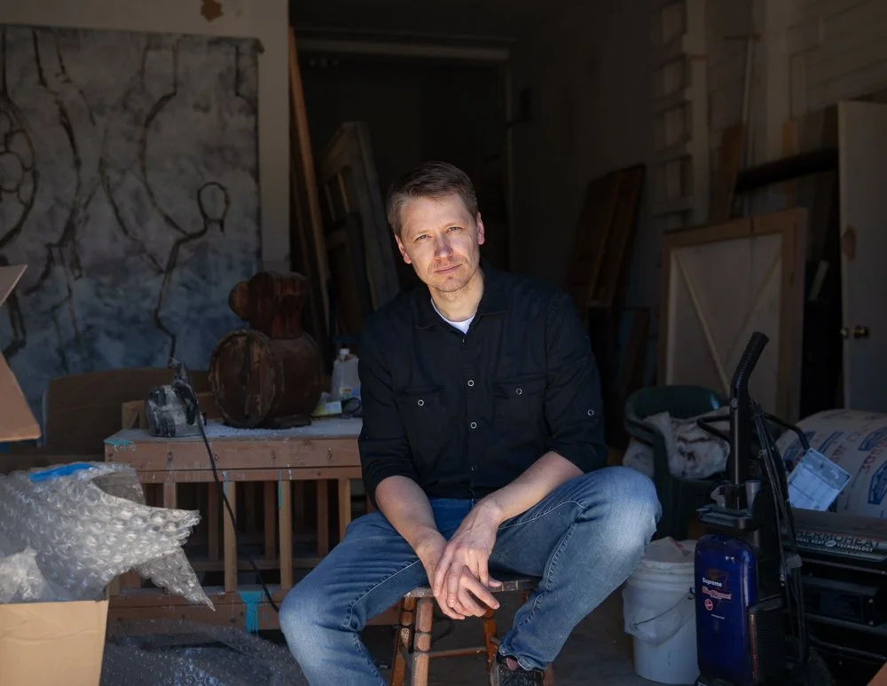 artist sitting on stool in studio