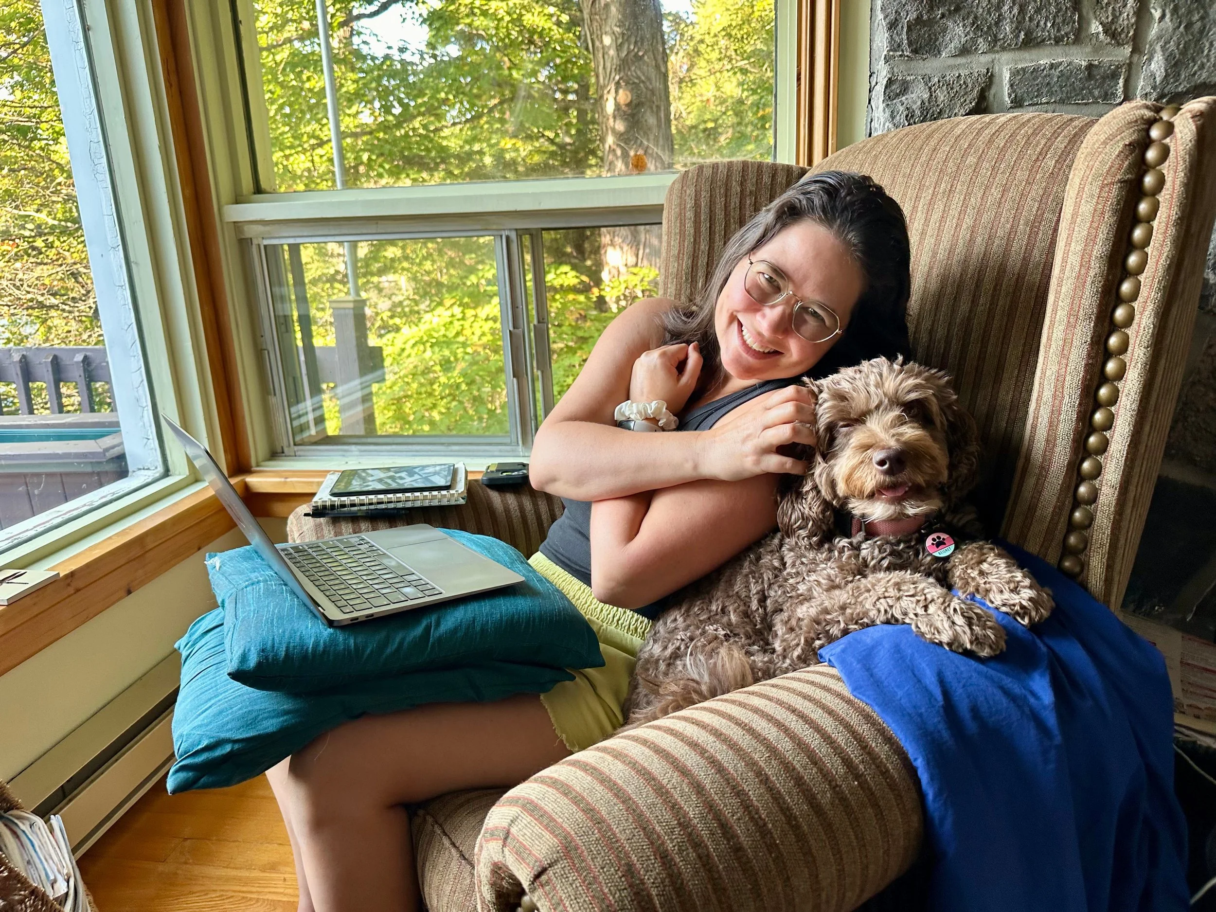 photo of author christine and cute labradoodle beignet sitting in a comfy chair