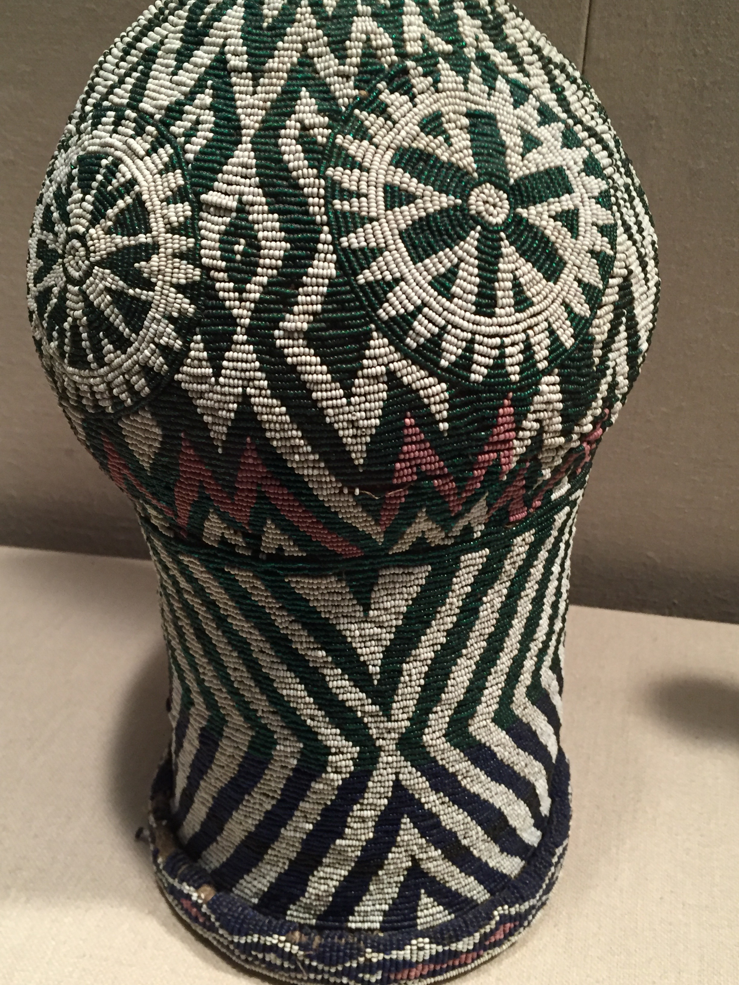 A green, beaded vase