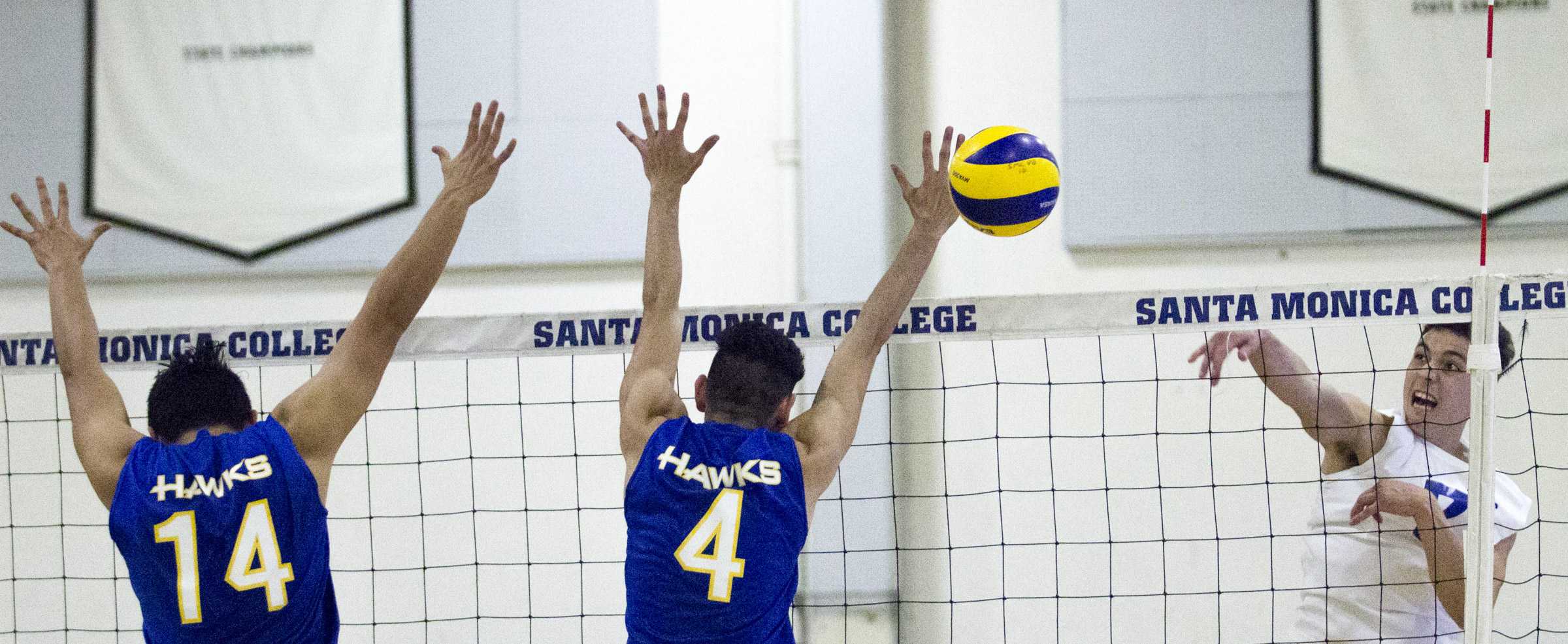  Santiago Canyon College Hawks freshman middle blocker Gustavo Marquez (14, left) and Santiago Canyon College Hawks freshman setter Christopher Solares (4, middle) attempt to block the attack of Santa Monica College Corsairs freshman outside hitter M