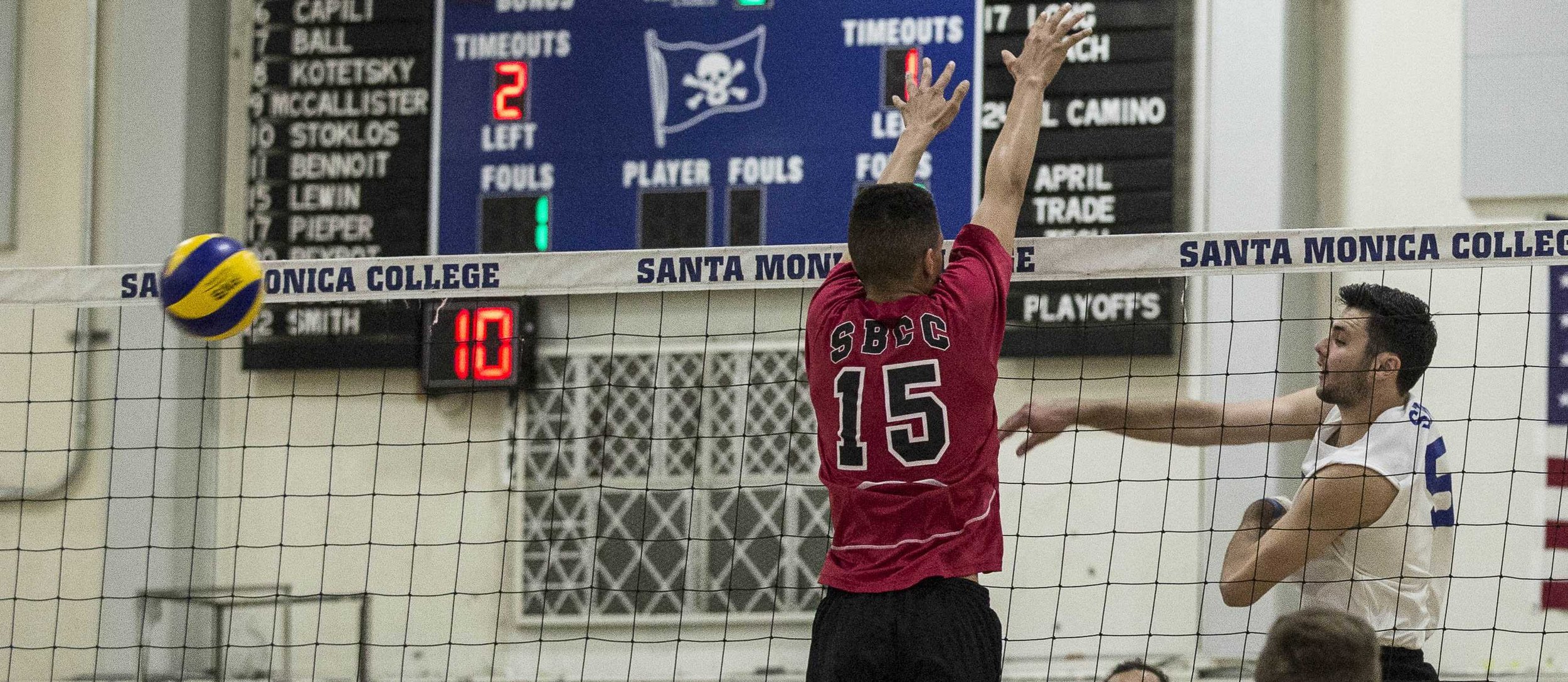  Santa Monica College Corsair freshmen right-side hitter Andrew Dalmada (5, right) successfully attempts a powerful spike as Santa Barbara Vaqueros freshman middle blocker (15, left) fails to defensively block the ball, allowing the Corsairs to score