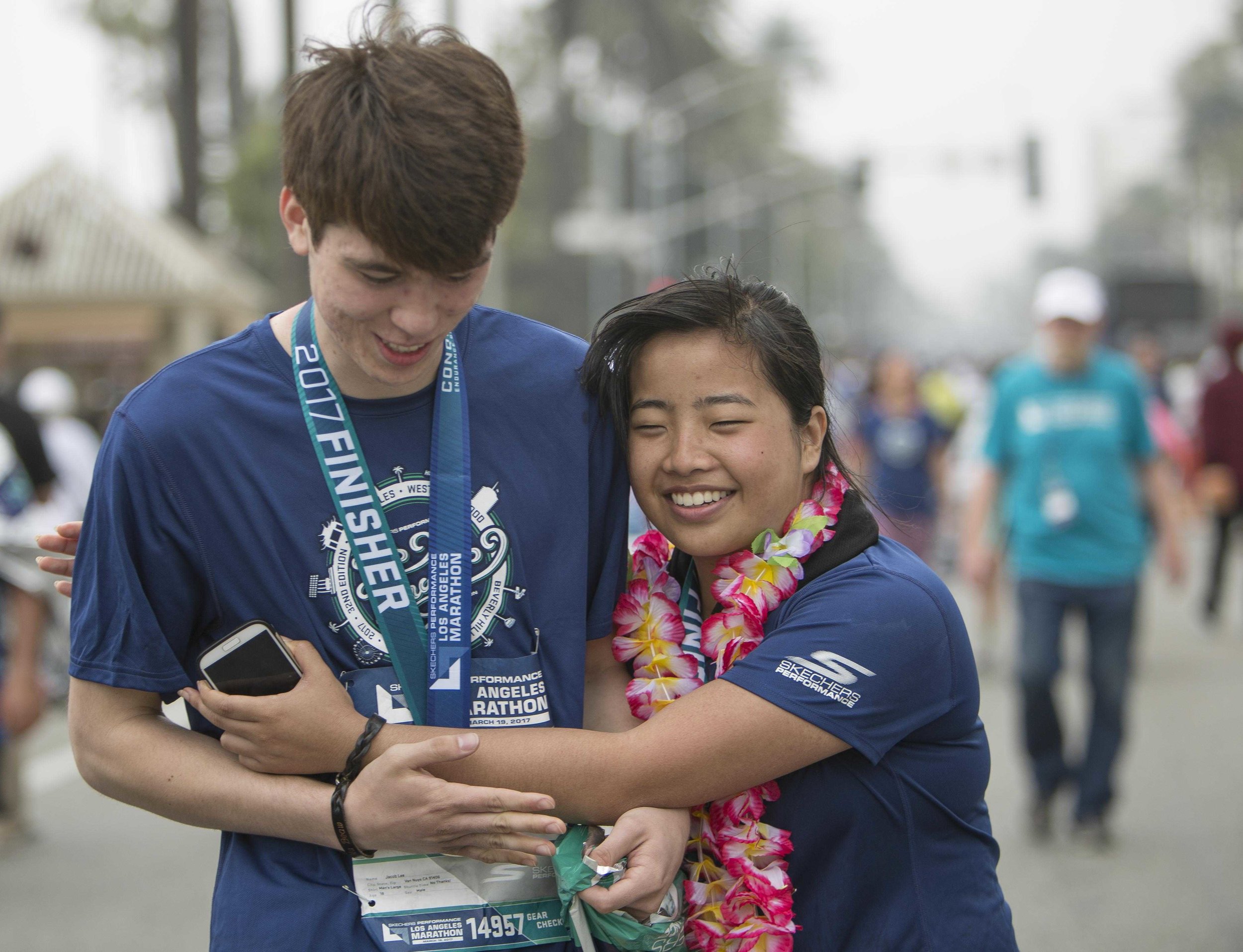  March 19, 2017. Kathy Pho (right) completes the 2017 LA Marathon and embraces her childhood friend Jacob Lee (left) who ran The LA Marathon along side her. Kathy Pho finished the marathon in five hours fourty nine minutes fifty four seconds. Santa M