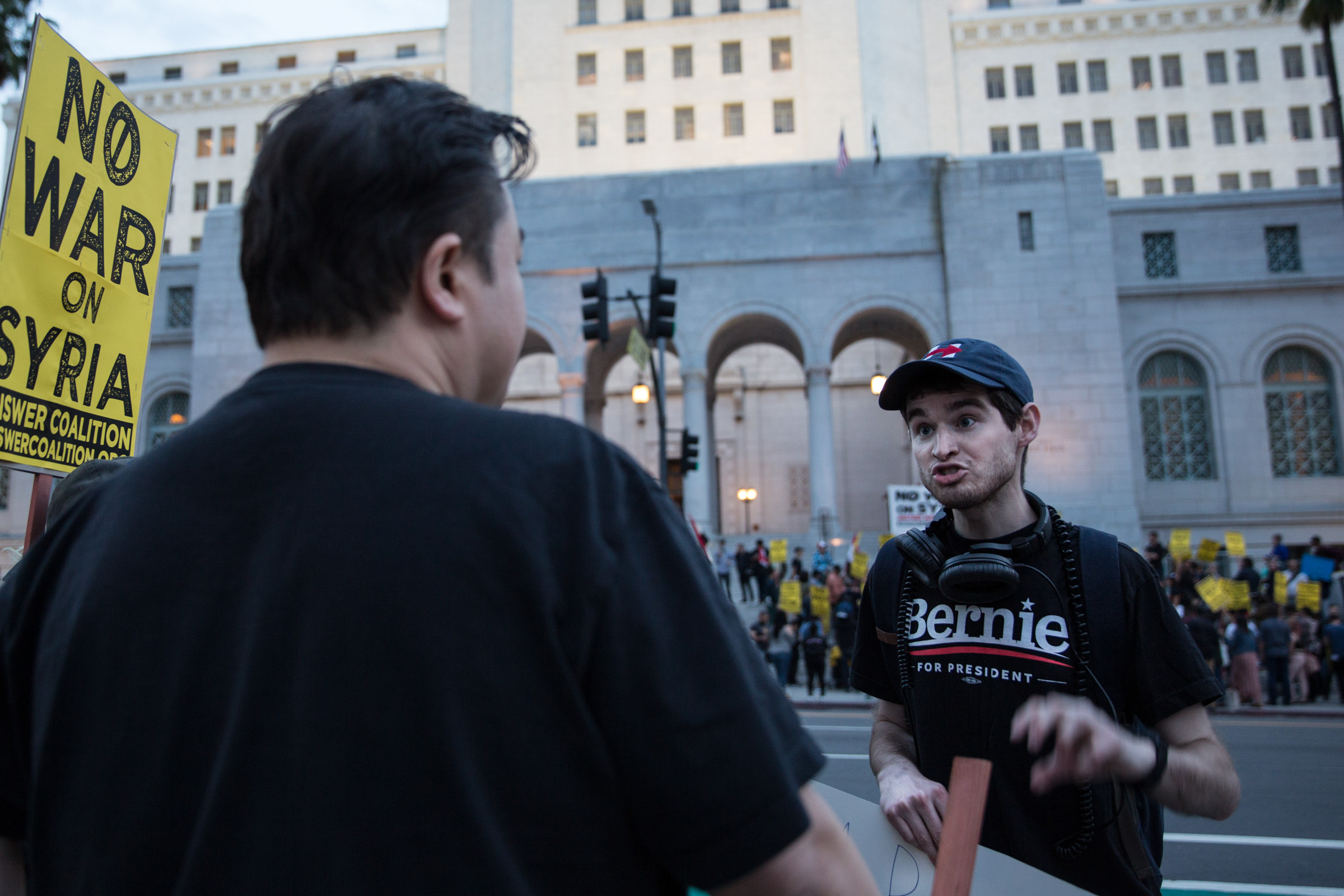  Eamon Harnett discusses Donald Trump's missile strike on Syria with an attendee of the anti-war protest in front of Los Angeles City Hall in Los Angeles, Calif. on April 8, 2017. Zin Chiang 