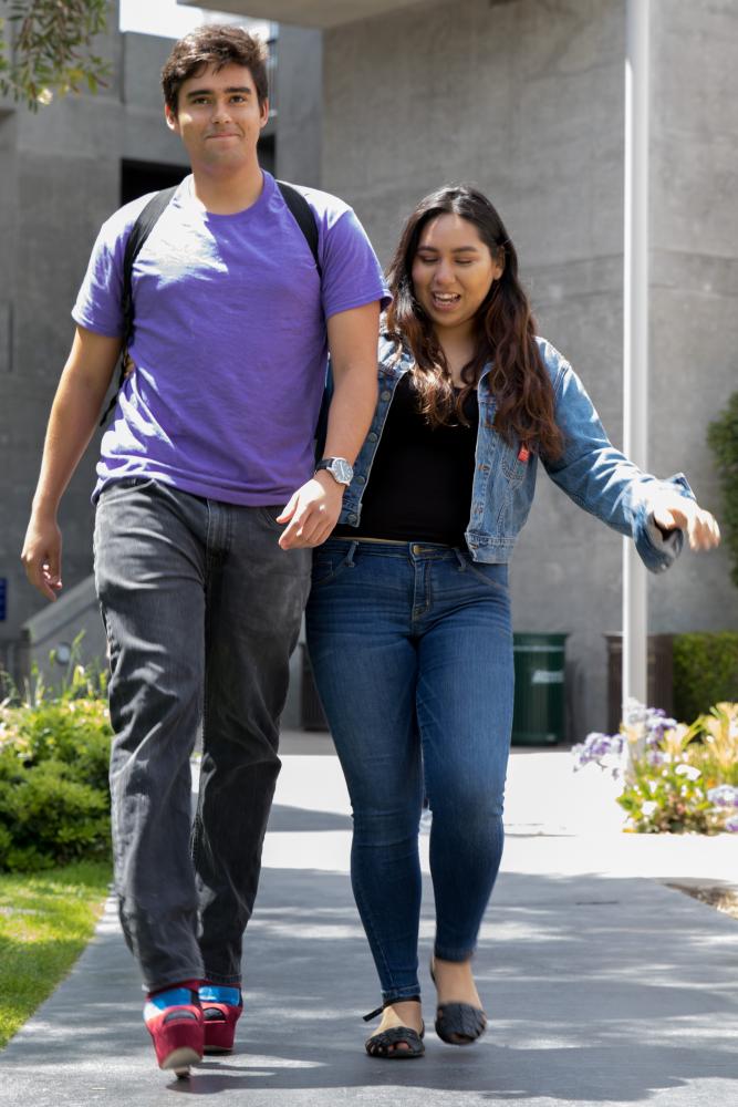  Santa Monica College Student Juan Parra (left) is assisted by Isabel Castillo (right) as he attempts to walk in high heels as he attempts to "Walk a mile in her shoes" to show support for victims of sexual misconduct as part of Santa Monica Colleges