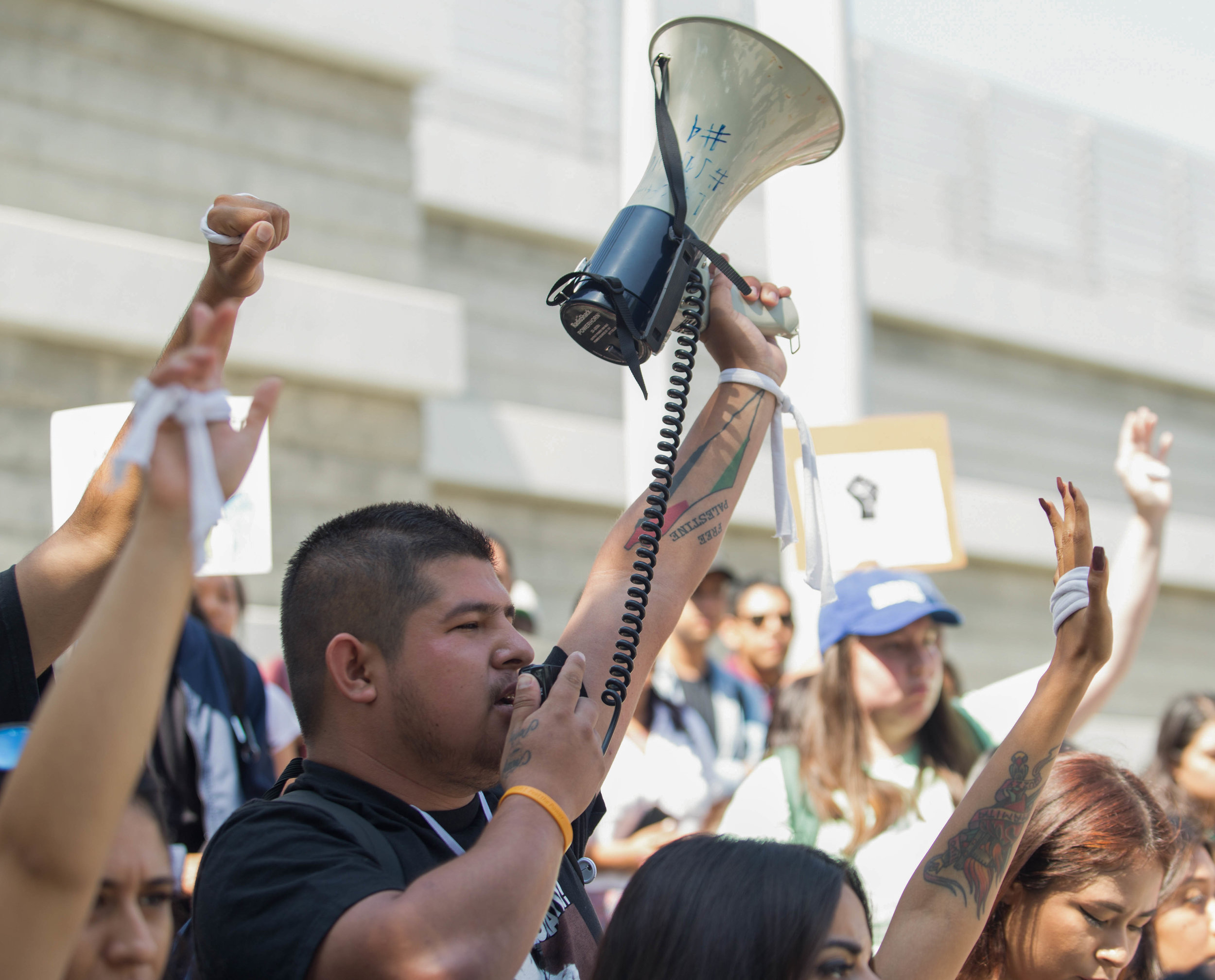  Edgar Gonzalez raises his Megaphone in the air along with other protesters raising their arms to show the strength they have to fight for DACA and against discrimination. The students chant phrases like "No papers, no fear" and "Undocumented, unafra