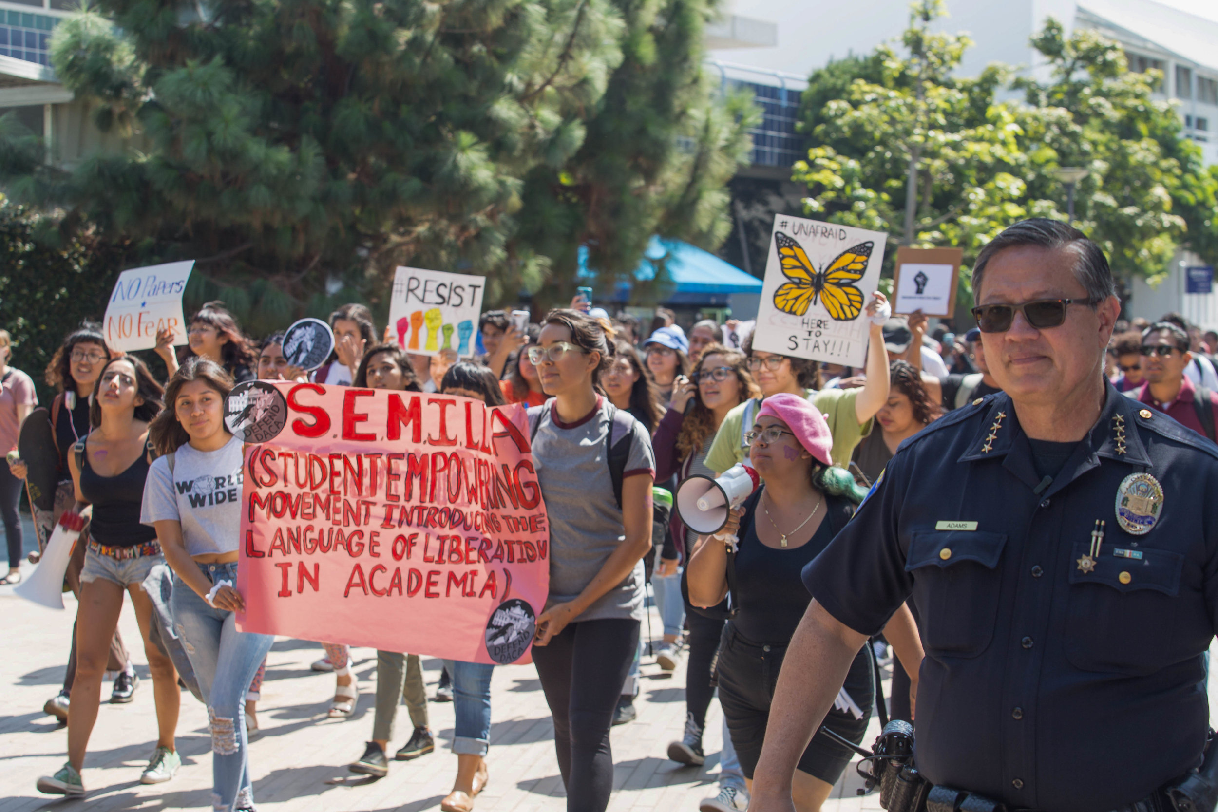  Santa Monica College Chief of Police Johnnie Adams ensures the safety of S.E.M.I.L.L.A. protestors as Estephanie Guardud holds a Megaphone as the protesters march through Santa Monica College Main Campus' Quad. The protesters attract the attention o