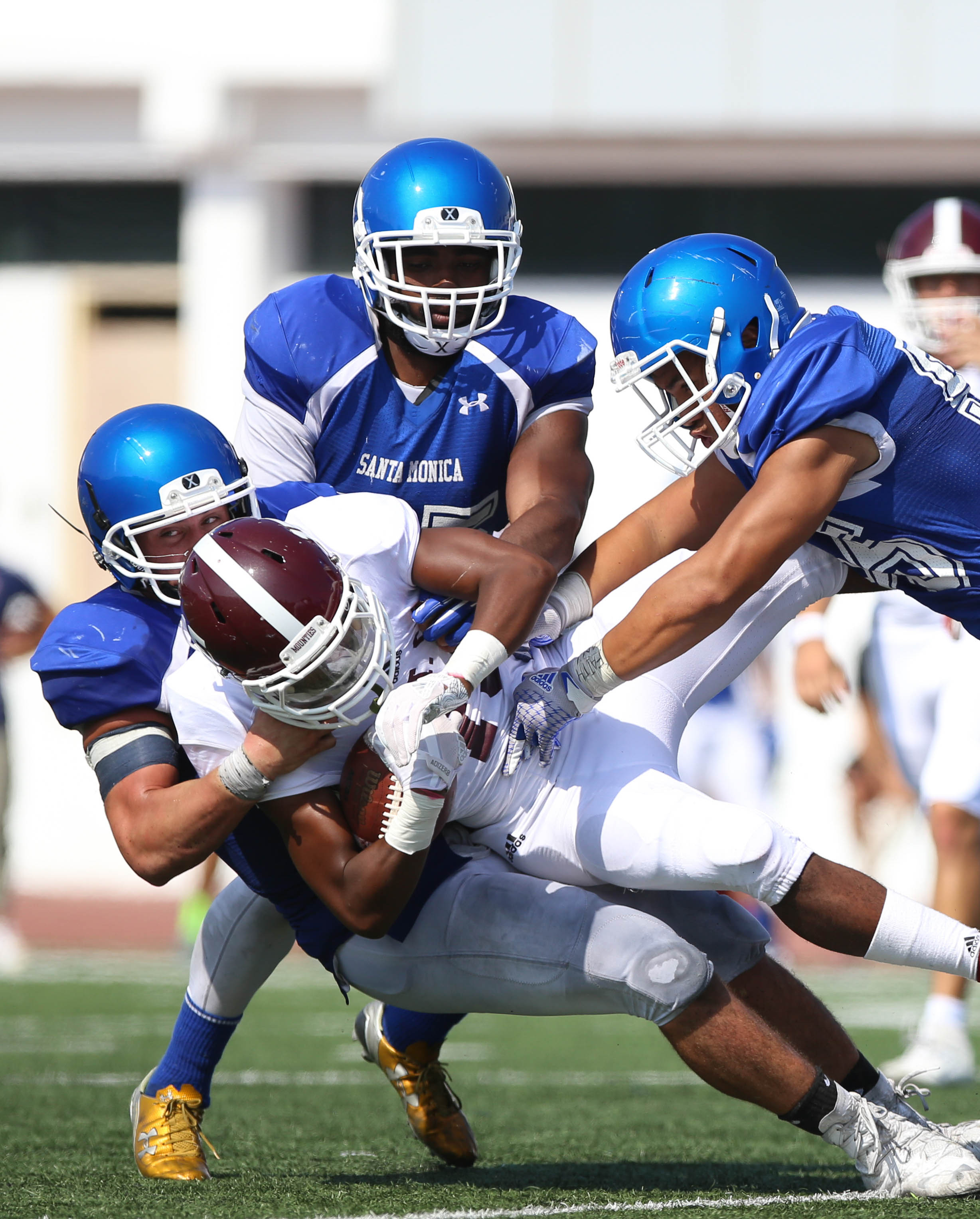  Chris Wein (44 left) along with the help of Chimechi Oparanozie (25 middle) and Iuta Mailoto (55 right) tackle Asfunso Elam(15 middle) at Corsair Stadium on Santa Monica College Main Campus on September 16th in Santa Monica, Calif. (Thane Fernandes)