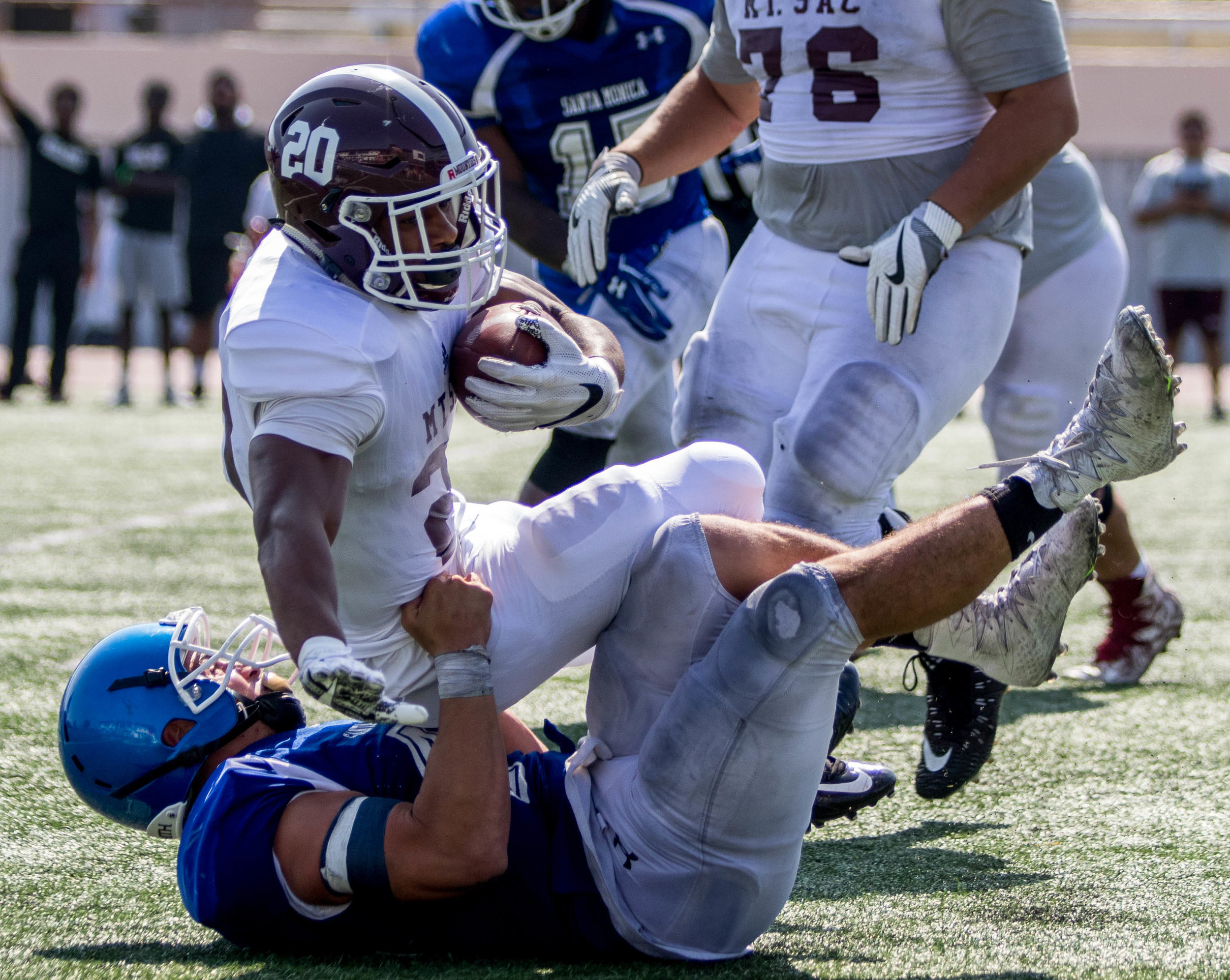  Santa Monica College Corsairs Sophomore Linebacker Chris Wein (Bottom) drags Mount San Antonio Mountees Sophomore Running Back Andre Walker (Middle, 20) to the ground to complete a tackle at the Corsair Stadium located on the Santa Monica College Ma