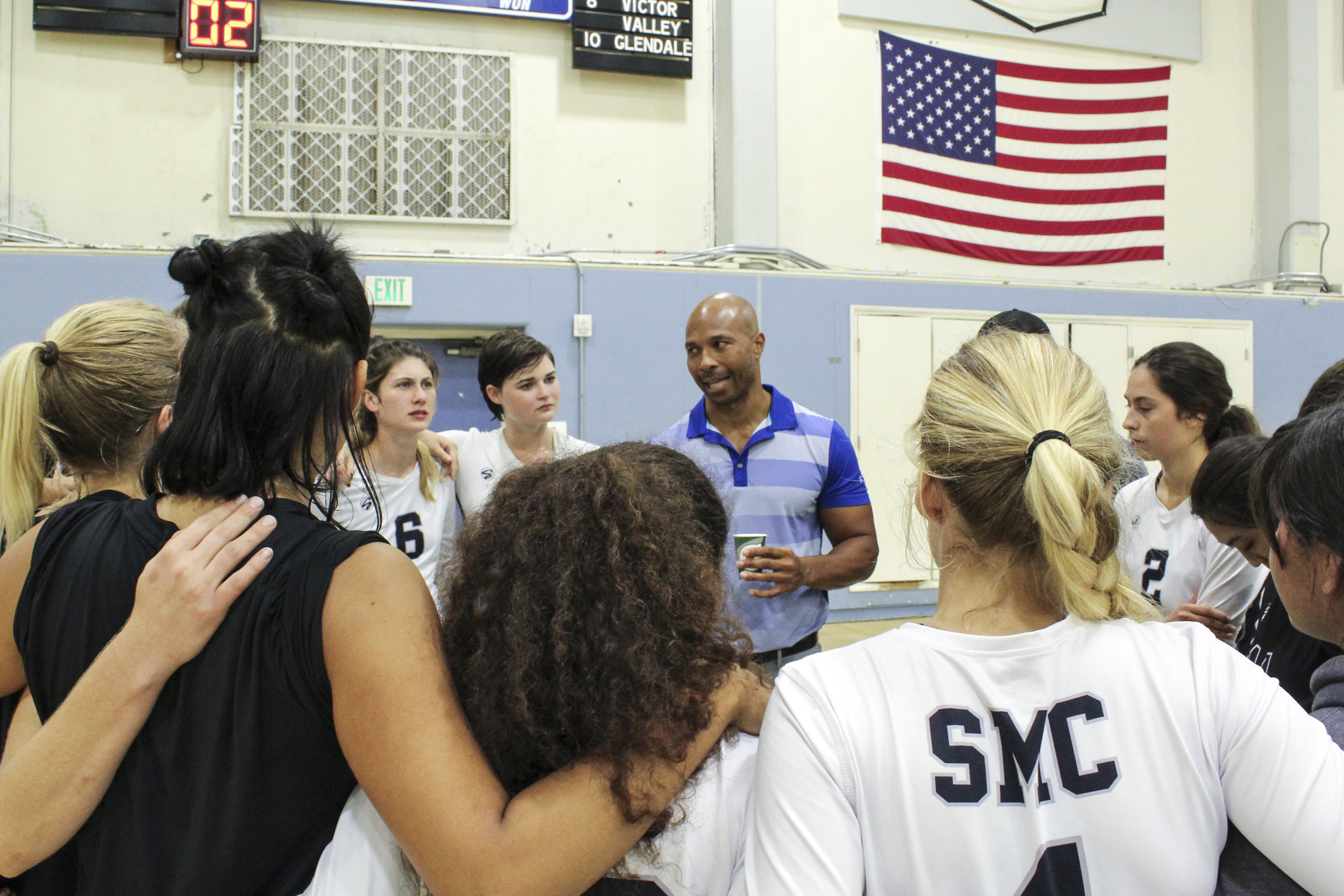  SMC Head Coach, Turhan Douglas, (middle) huddles with the women’s volleyball team during a break in the action from their thrilling 3-1 set victory against the Marauders of Antelope Valley in the Corsair Gymnasium, located on the Santa Monica Colleg