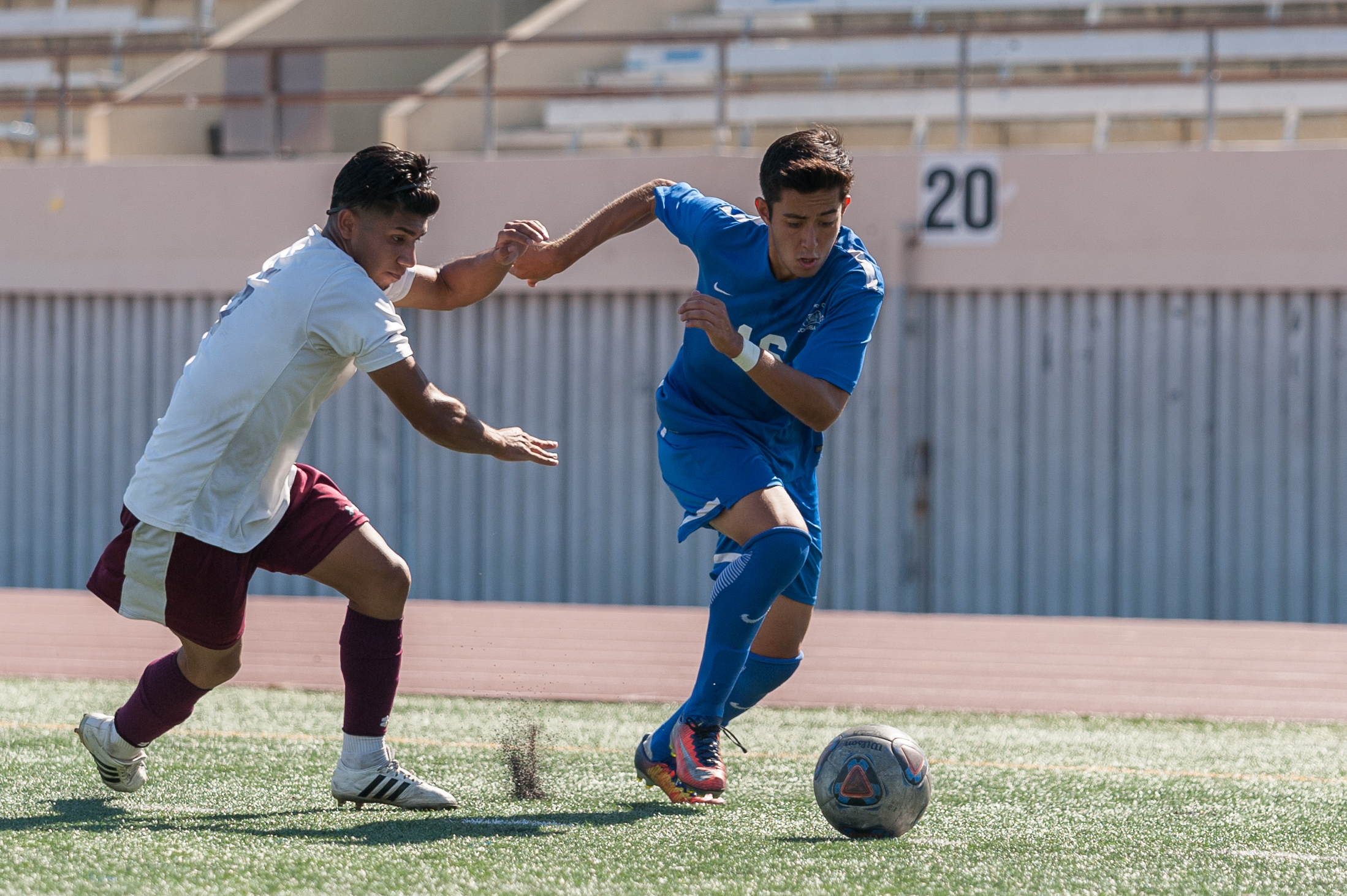  Midfielder Carlos Rincon (16,right) moves the ball up the field while being contested by Angel Barajas (5,left) of Victor Valley College. The Santa Monica College Corsairs won the game 2-0 against the Victor Valley Rams. The match was held at the Co