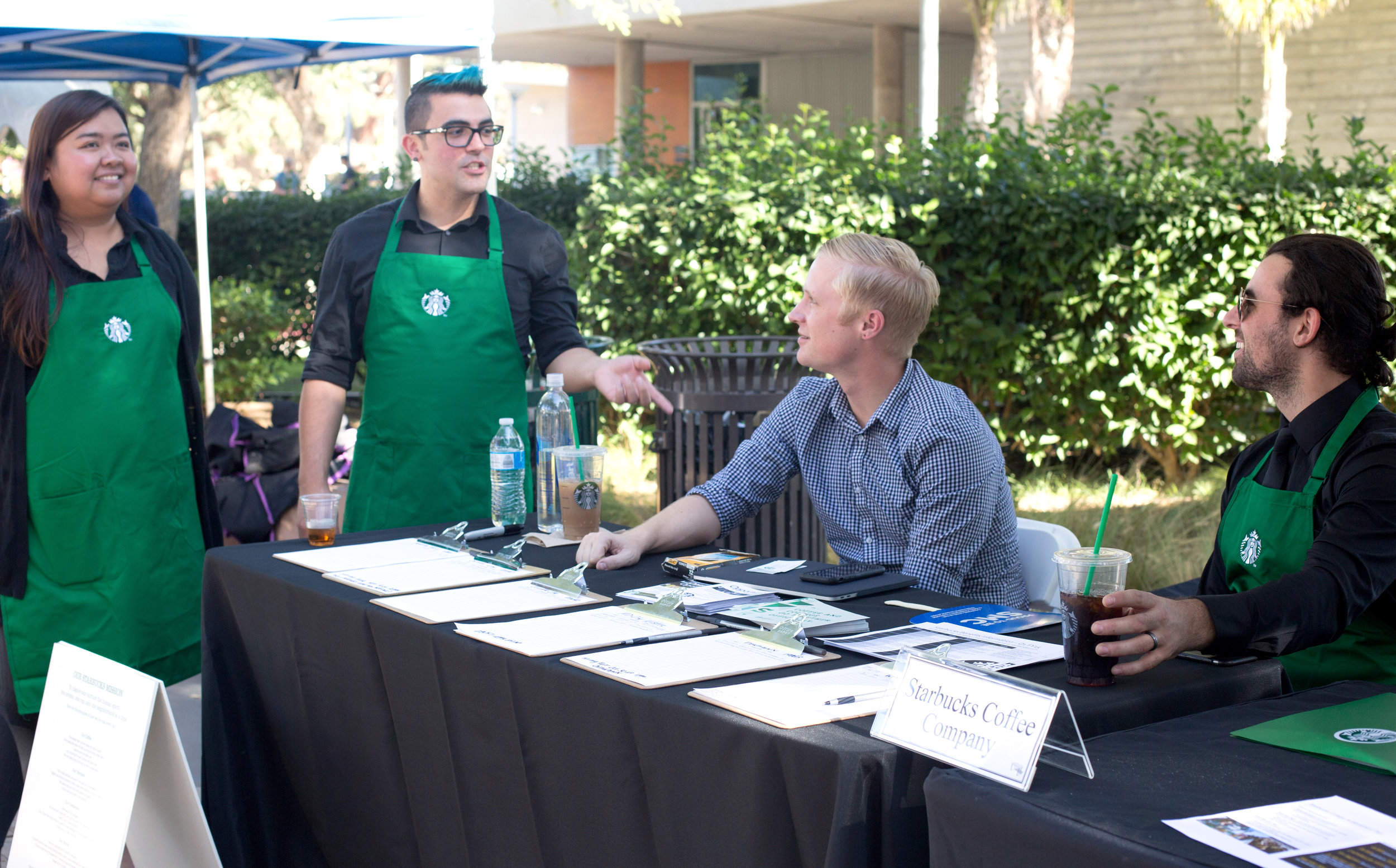  (L to R) Starbucks Store Managers Carla Henriquez and Vincent Perez at the Starbucks employment booth with District Manager August Anderson and Store Manager Jarrod Jacobus scouting for friendly faces in the student population at the Job Fair in San