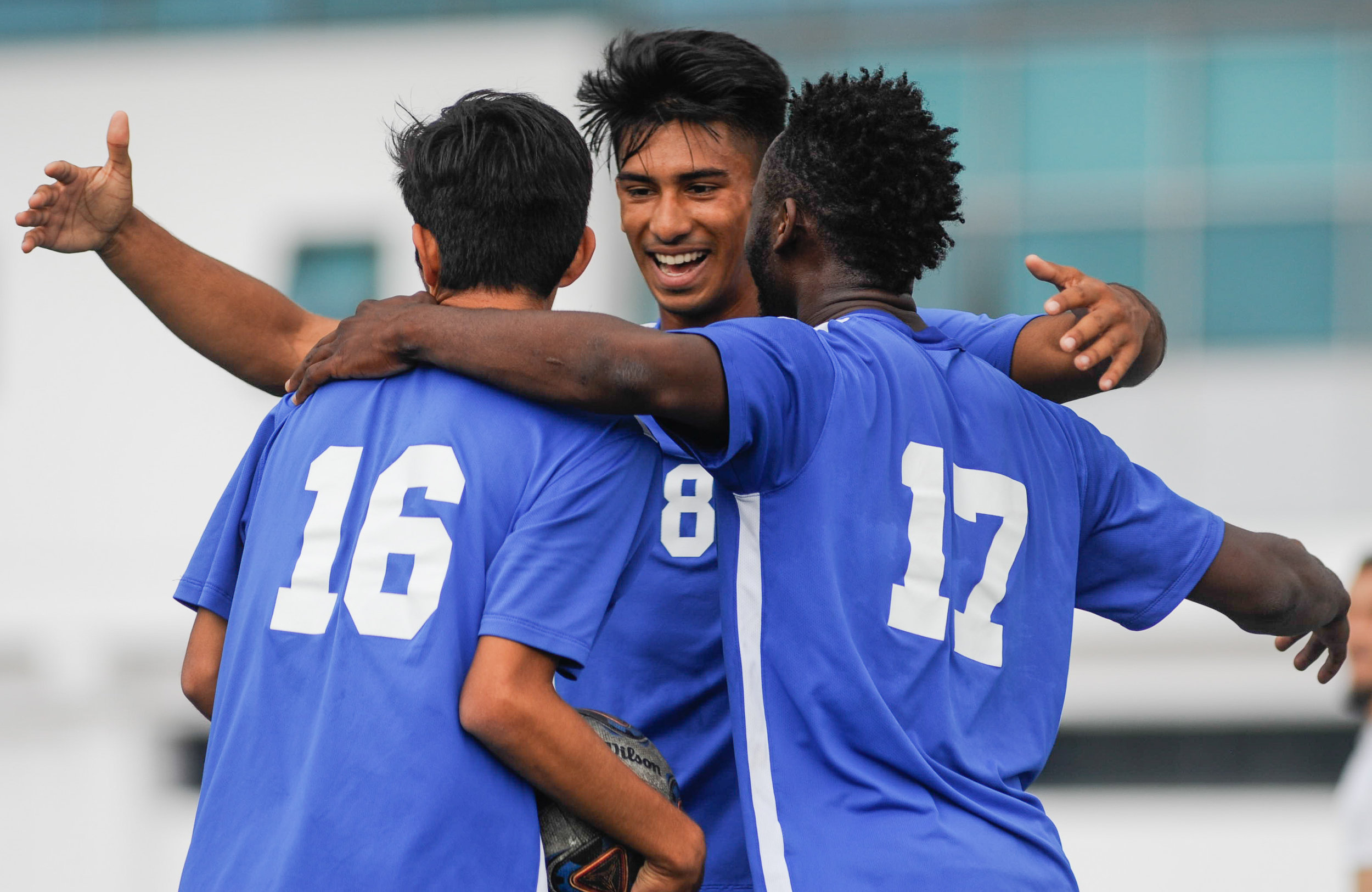  Midfielder Carlos Rincon (16,Left) is embraced by forward Andy Naidu (8,Middle), and midfielder Cyrille Njomo (17,Right) of Santa Monica College as they celebrate Rincon's goal in the first half, the only goal scored by the Corsairs in the match. Th