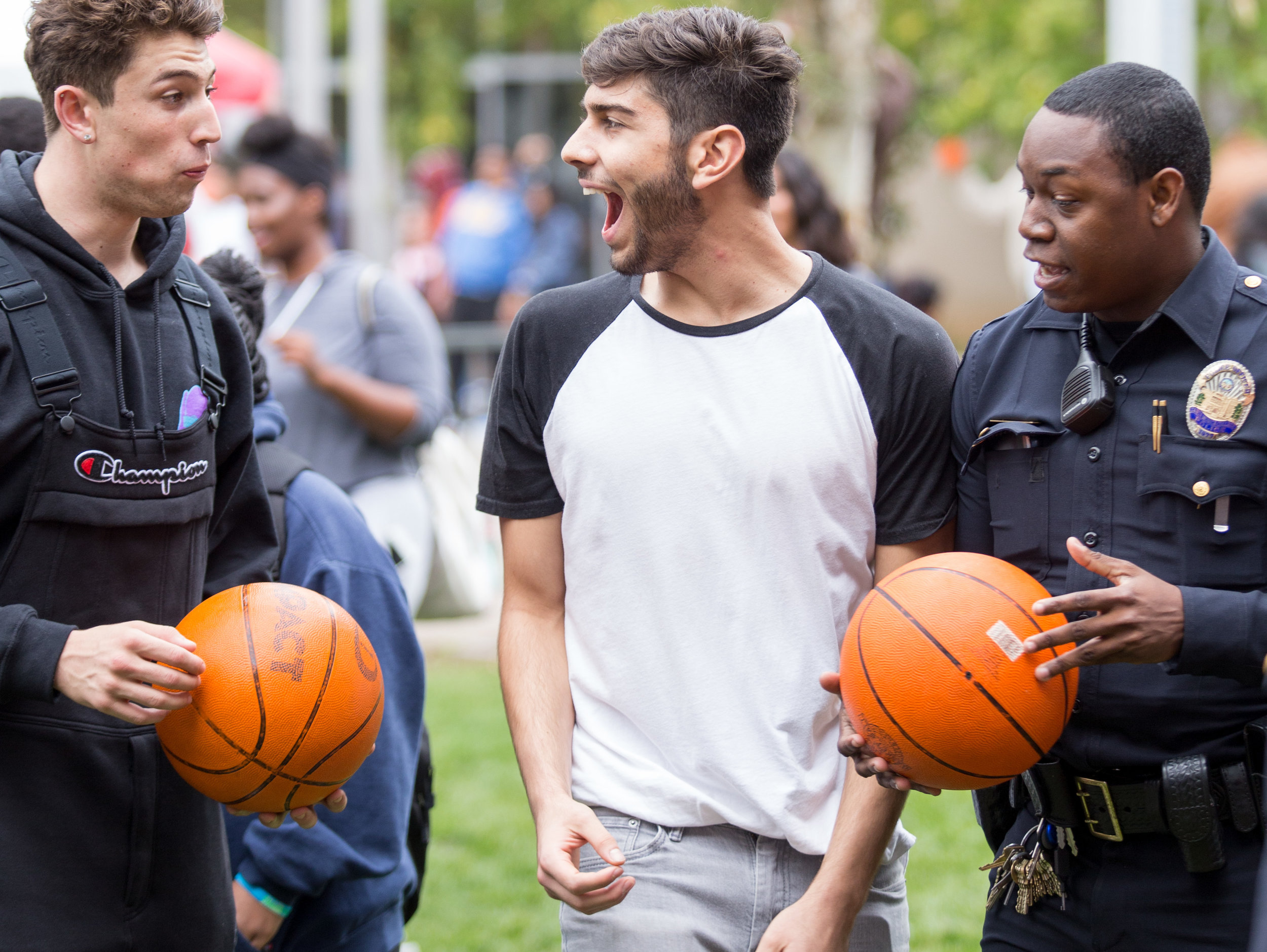  Cousins Marcus Nasrollahy (CQ left) and Eman Vafa (middle) shoot hoops with Santa Monica College Police Officer Jester (right) on the Santa Monica College's Main Campus Quad for the Associated Students' Homecoming Carnival on Halloween on Tuesday, O