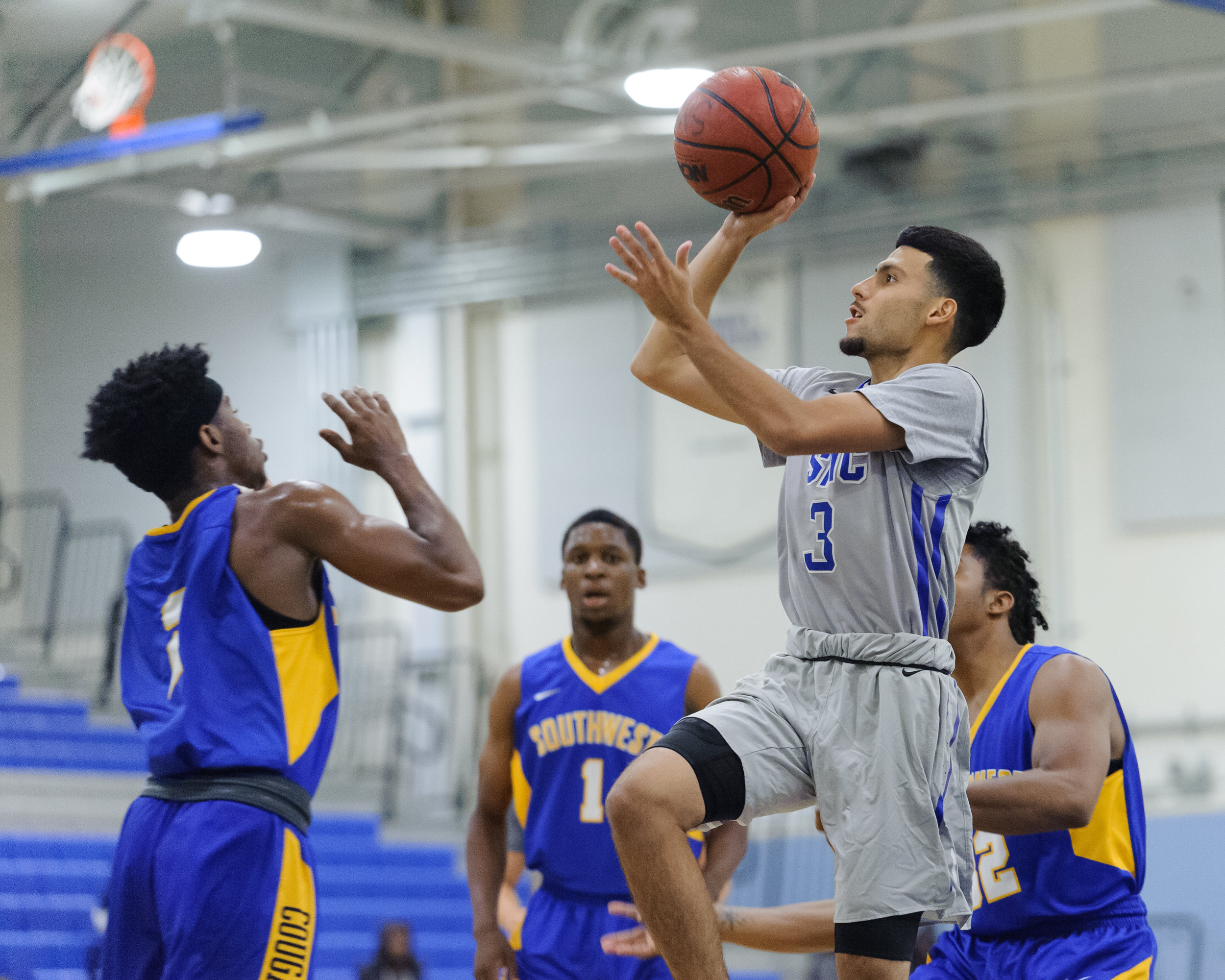  Guard Ernie Valadez (3) of Santa Monica College shoots a floater over the top of the Southwest College defense. The Santa Monica College Corsairs win their first home game of the season 84-53 against the Southwest College Cougars. The game was held 