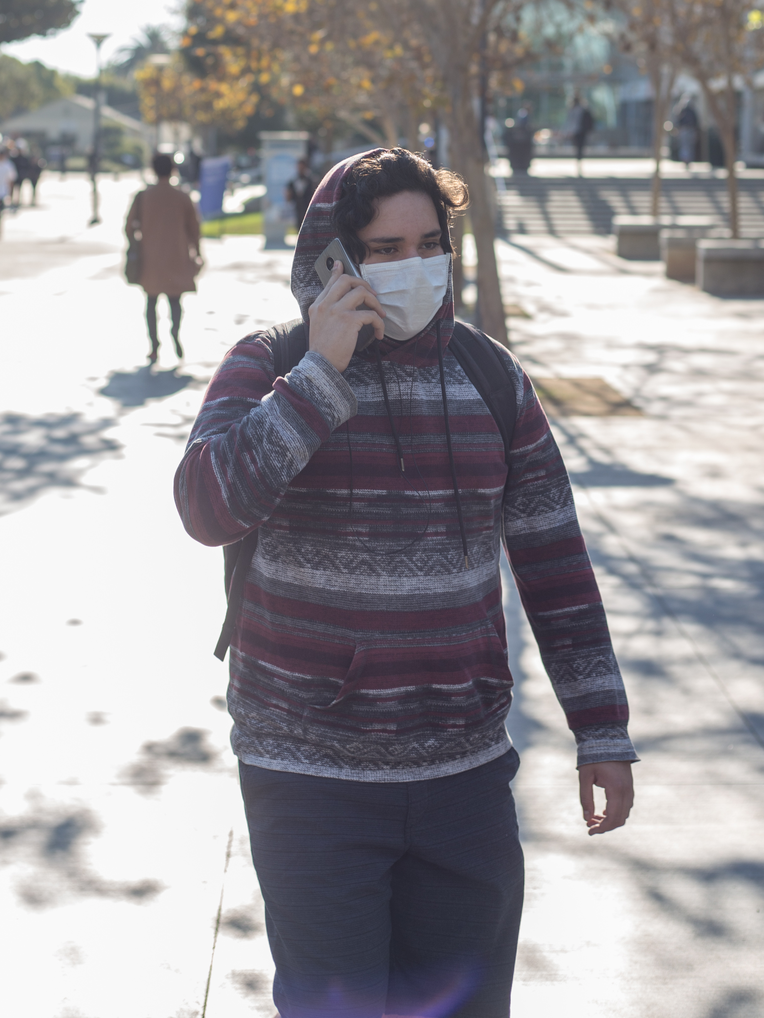  SMC Student walks on campus with a mask over his mouth and nose due to the poor air quality as a result from the Skirball fire after an email was sent out at 8:49 am by SMC informing students that classes are canceled due to the close proximity to t