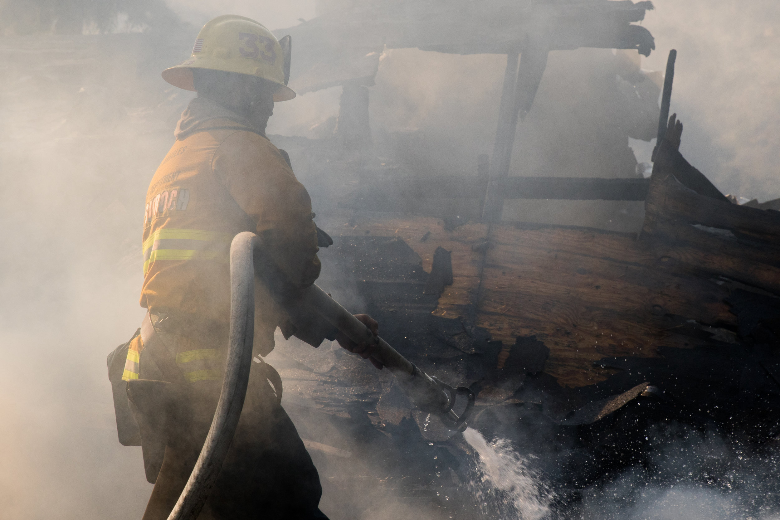  Scott Kwasigroch prepares his hose to battle one of the many house fires that occurred because of the Skirball Fire. The fire burned 450 acres and shut down the 405 freeway on Dec.&nbsp;6, 2017 in West Los Angeles Calif. (Photo by Zane Meyer-Thornto