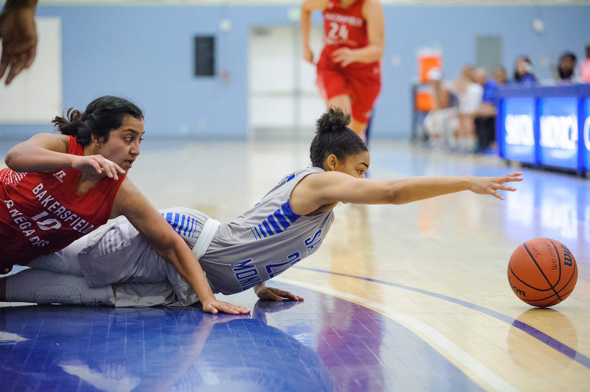  Guard Jinea Cole (22,Right) of Santa Monica College dives for a loose ball against Belen Rivera (10,Left) of Bakersfield College. The Santa Monica College Corsairs lose the game 62-72 to the Bakersfield College Renegades. The game was held at the SM
