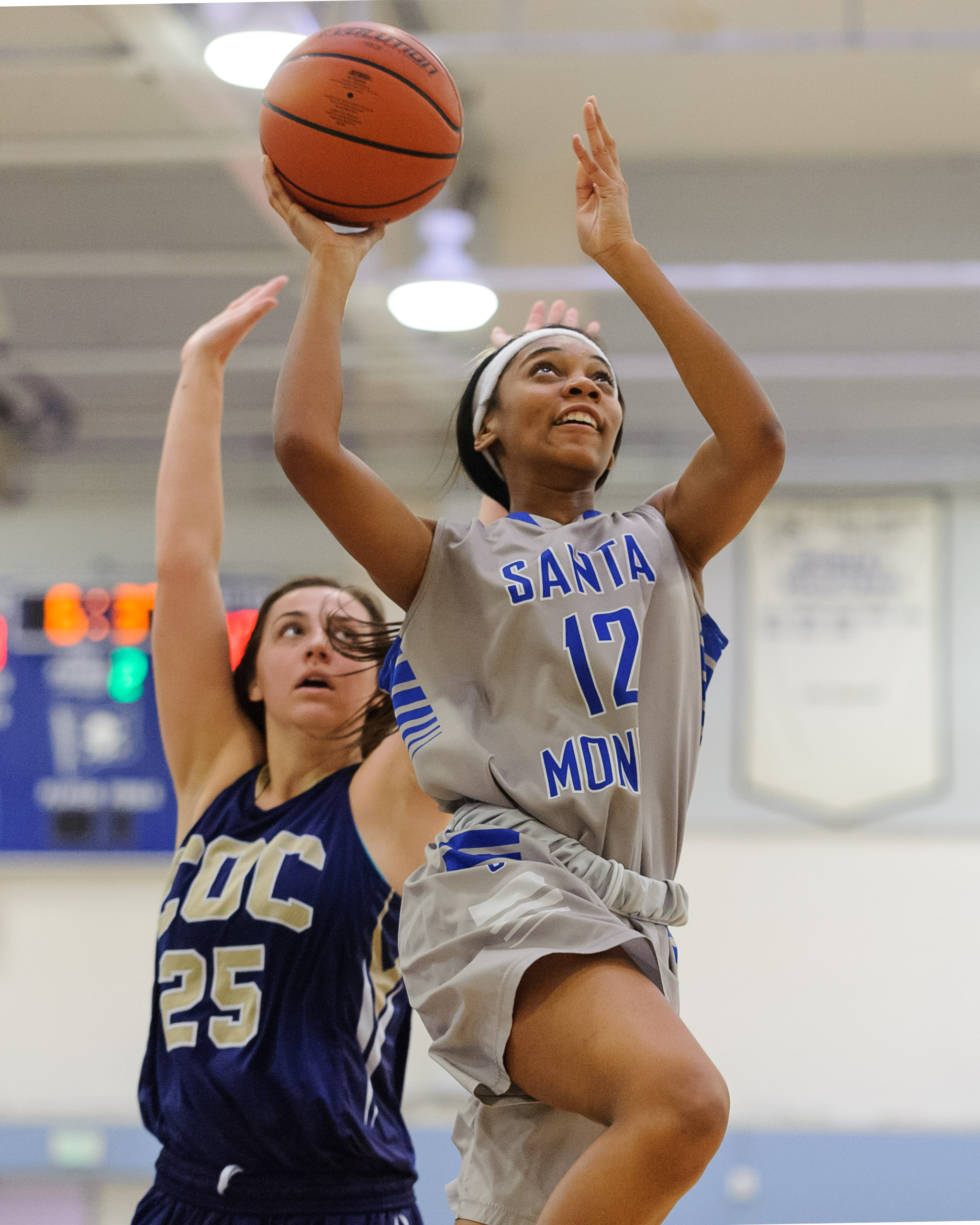  Forward Jazzmin Oddie (12,Right) of Santa Monica College passes Kalli Self (25,Left) of the College of the Canyons and soars towards the basket for a shot. The Santa Monica College Corsairs lose the game 108-70 to the College of the Canyons Cougars.