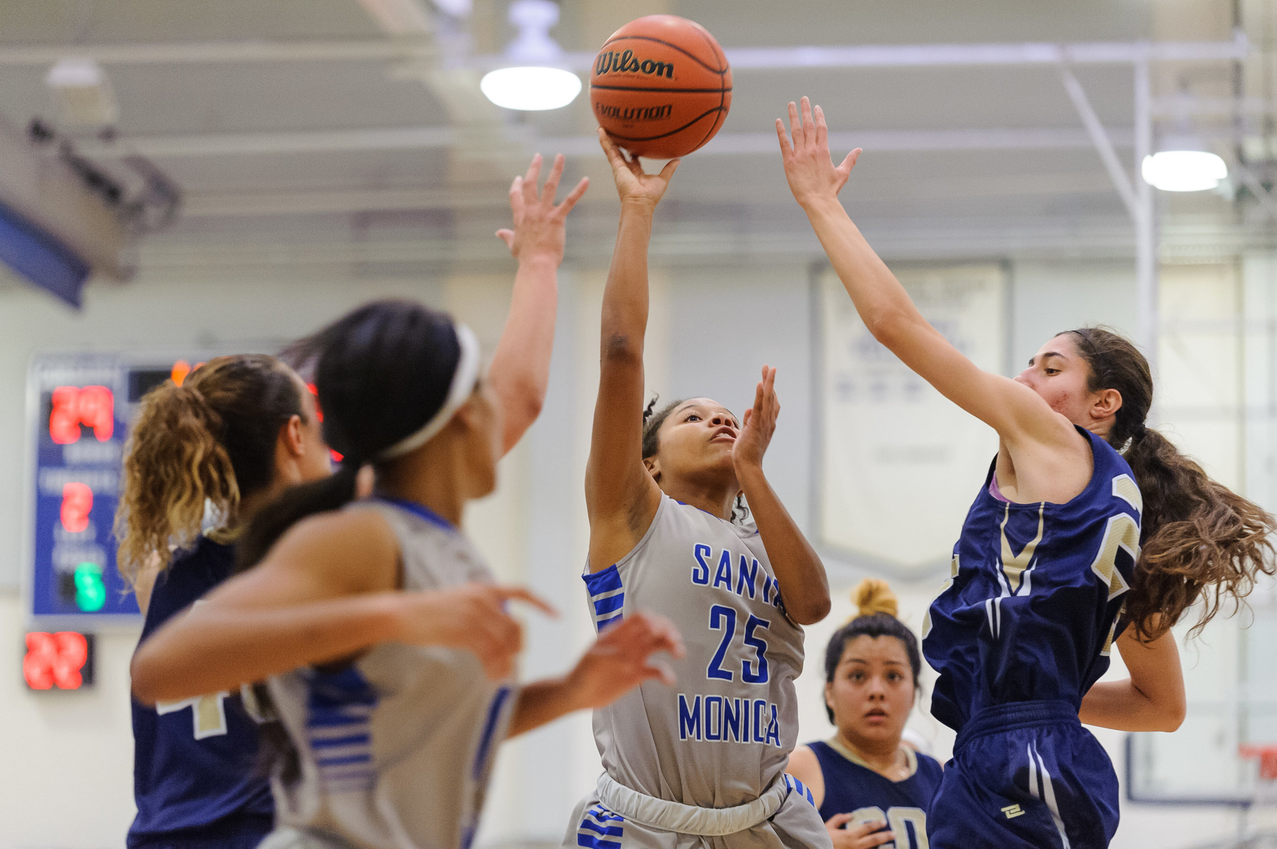  Mija Williams (25) of Santa Monica College shoots a shot in the lane while swarmed by the College of the Canyons defense. The Santa Monica College Corsairs lose the game 108-70 to the College of the Canyons Cougars. The game was held at the SMC Pavi