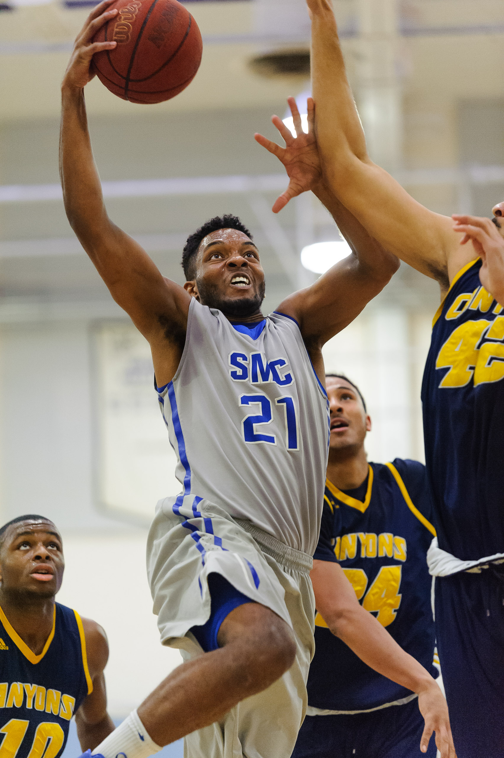  Forward Khalil Taylor (21) of Santa Monica College goes up for a contested layup as Philip Webb (42,Right) of the College of the Canyons attempts to block Taylor. The Santa Monica College Corsairs lose the game 74-72 to the College of the Canyons Co