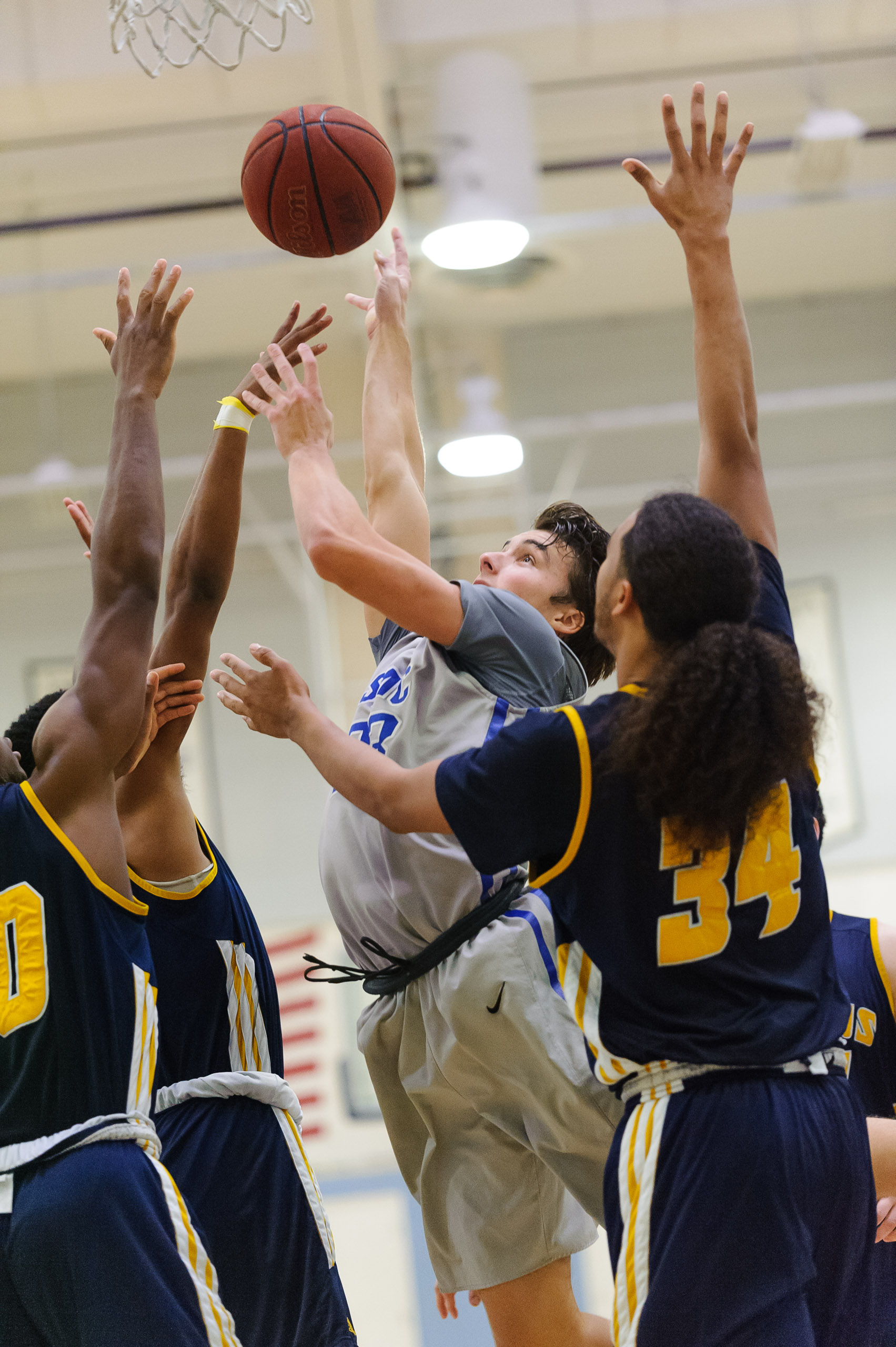  Forward Dayne Downey (23,Middle) of Santa Monica College goes up for a shot attempt by the basket while contested by College of the Canyons defense. The Santa Monica College Corsairs lose the game 74-72 to the College of the Canyons Cougars. The gam