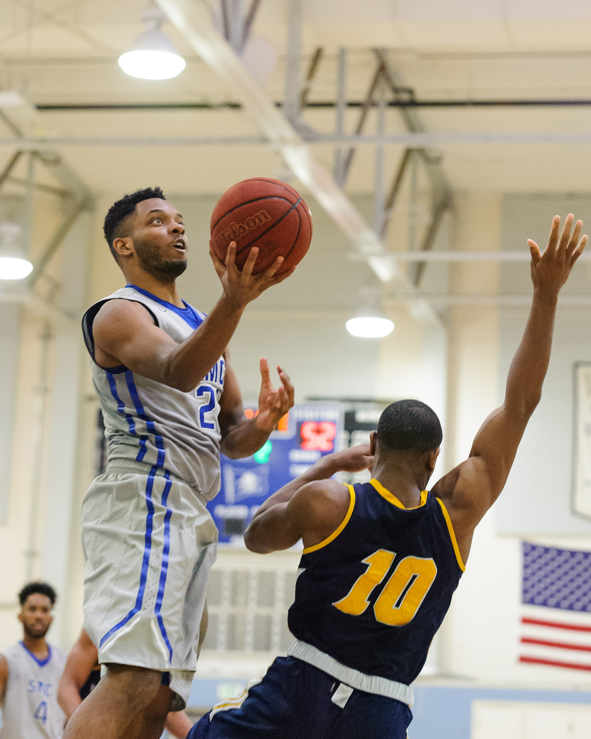  Forward Khalil Taylor (21,Left) of Santa Monica College goes up for a layup while guarded by Michael Kalu (10,Right) of the College of the Canyons. The Santa Monica College Corsairs lose the game 74-72 to the College of the Canyons Cougars. The game