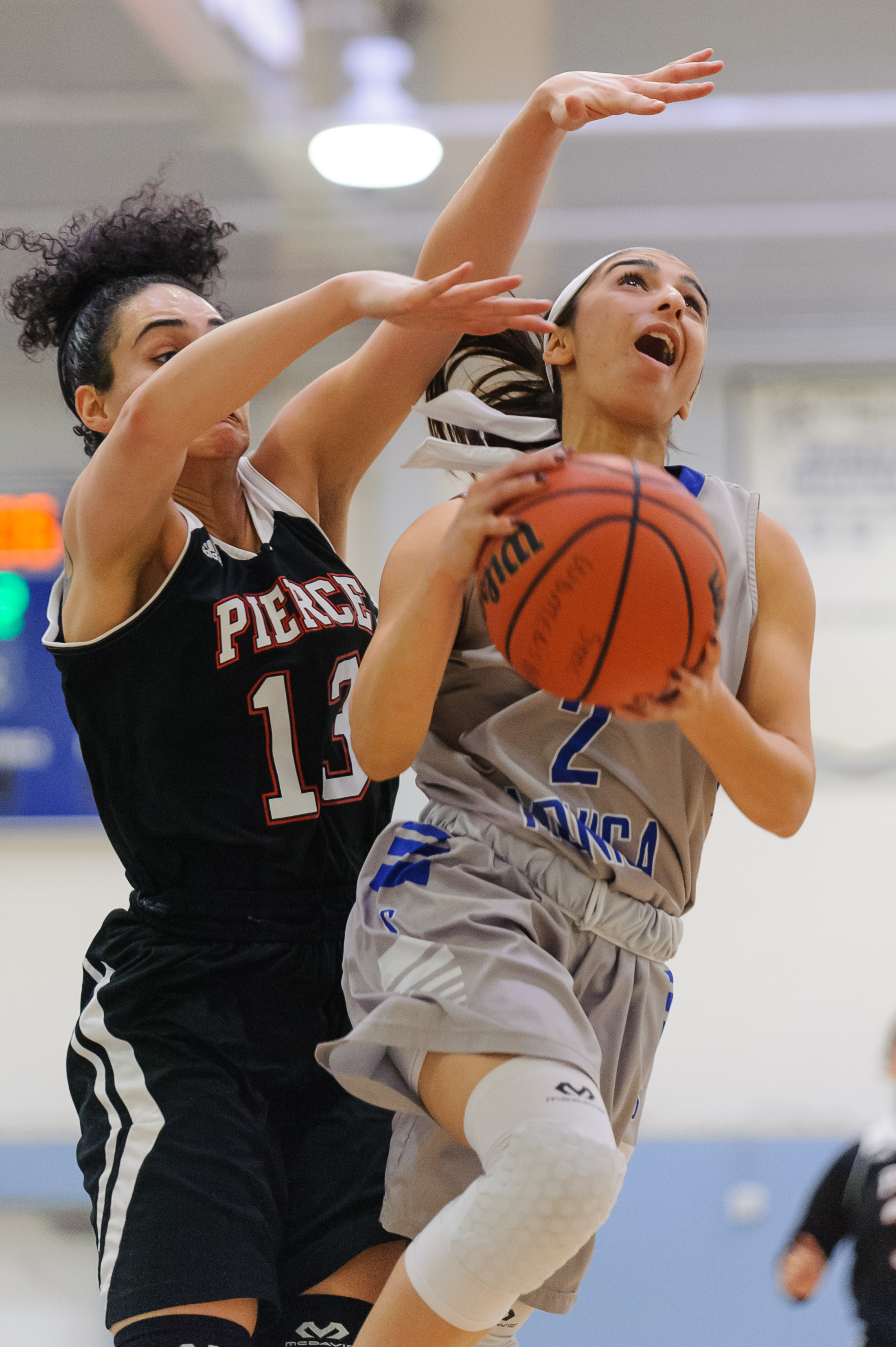  Guard Jessica Melamed (2,Right) of Santa Monica College attempts a difficult shot contested by Diana Kohanzad (13,Left) of Pierce College. The Santa Monica College Corsairs win their final game of the season 76-53 against the Pierce College Brahmas.
