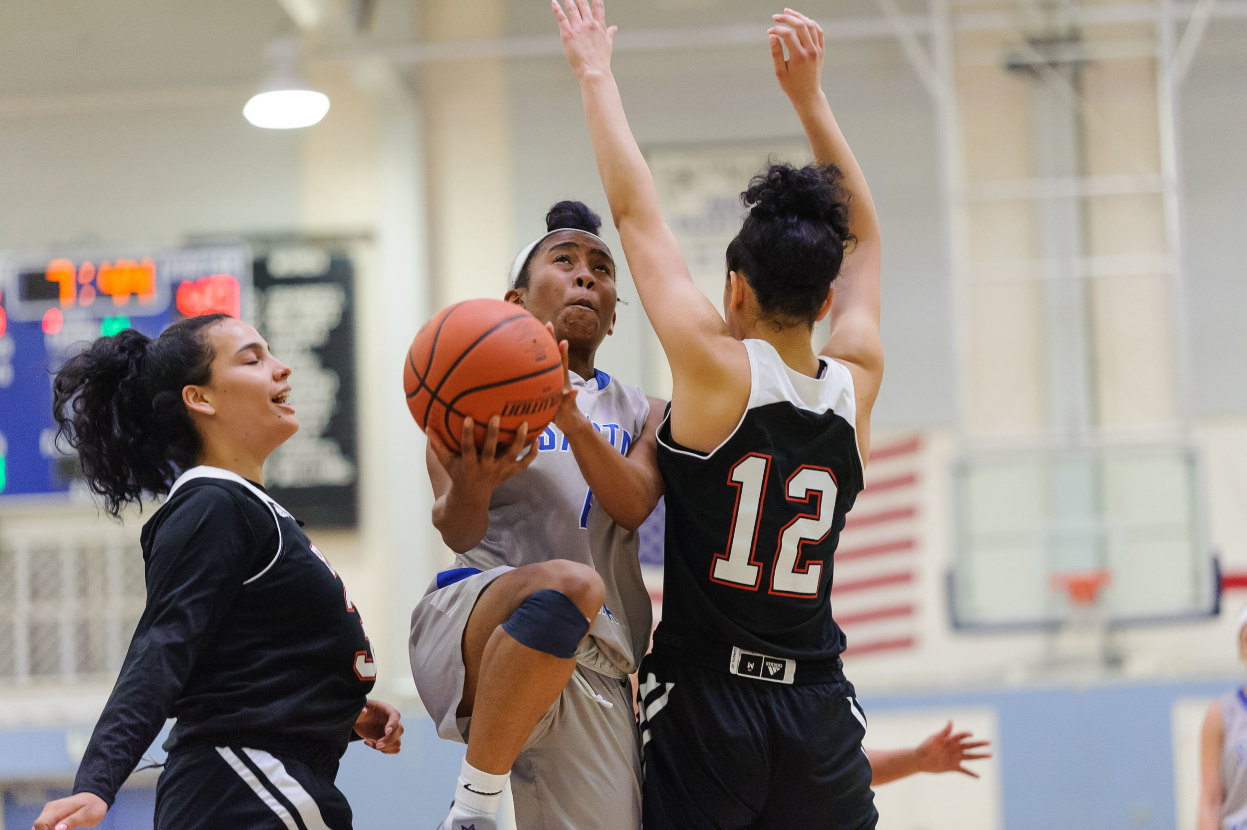  Guard Lisa Hall (4,Middle) of Santa Monica College goes up for a layup while contested by Adriana Penate (12,Right) of Pierce College. The Santa Monica College Corsairs win their final game of the season 76-53 against the Pierce College Brahmas. The