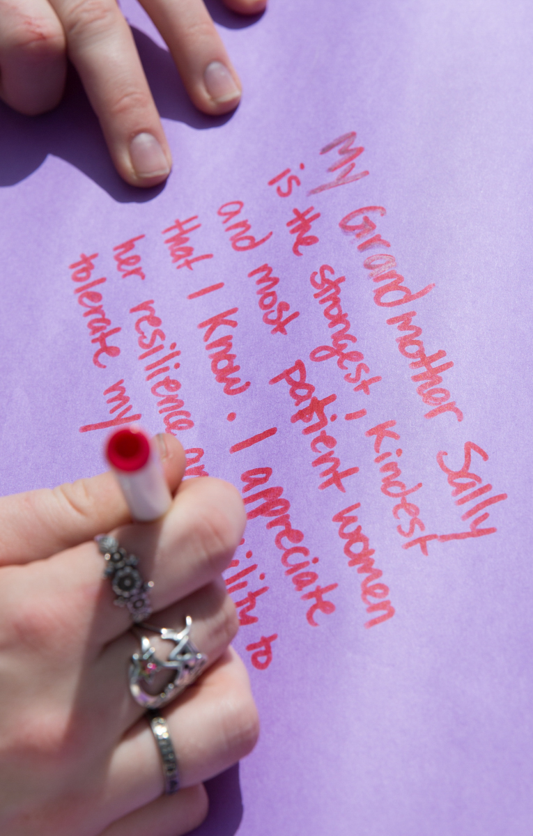  An attendee of the Santa Monica College International Women’s Day event takes part in the festivities by writing about the women in their life that inspire on purple paper, a universal color that represents all women, during the SMC International Wo