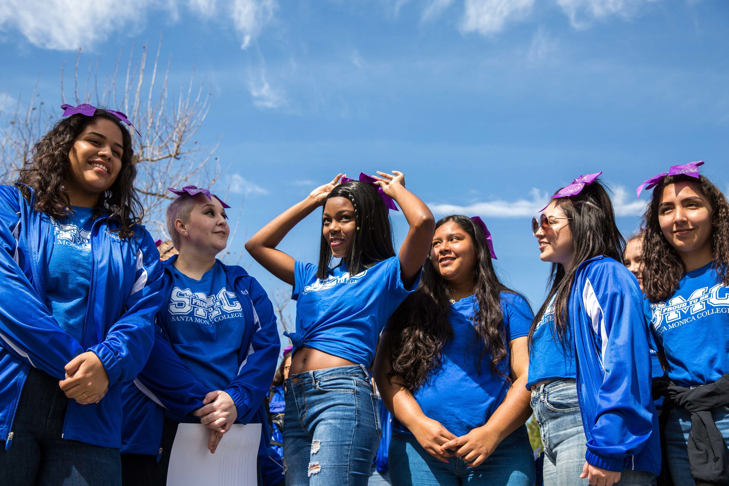 Members of the Santa Monica College cheer squad put on their purple bows with pride during the Santa Monica College International Women’s Day event that took place on the SMC main campus, in front of the Library Walkway, in Santa Monica California on Thursday, March 8, 2018. Internationally, the color purple that the women are wearing signifies dignity and justice and is a color that is universal in representing all women. (Corsair Photo: Matthew Martin)