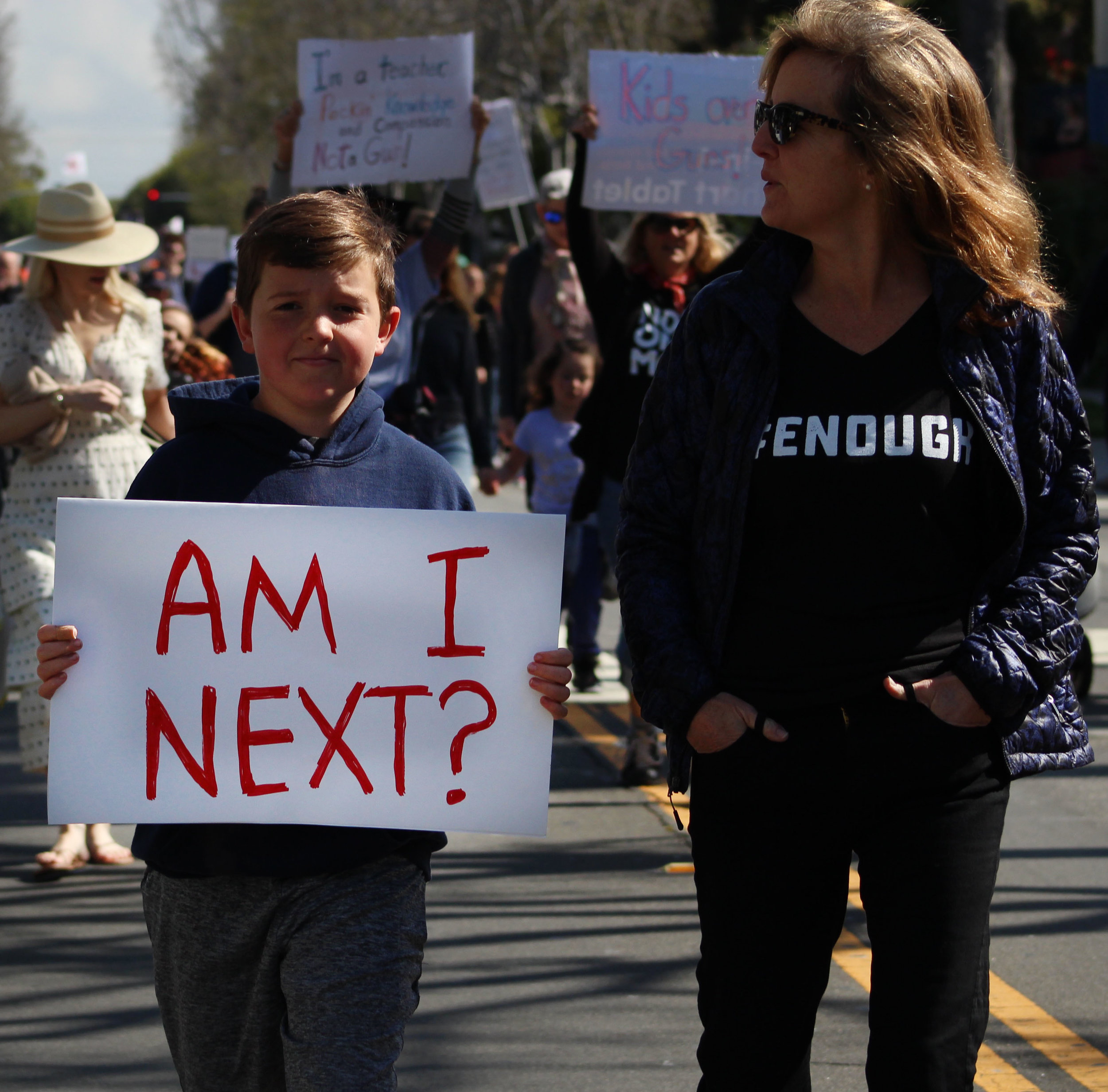  Jack Schneider and his mom, Laura Scheider, walk within the crowd holding homemade signs and chanting along with the protest on Montana Avenue in Santa Monica, California.&nbsp;On Saturday, March 24, 2018. (Pyper Witt/Corsair Photo) 