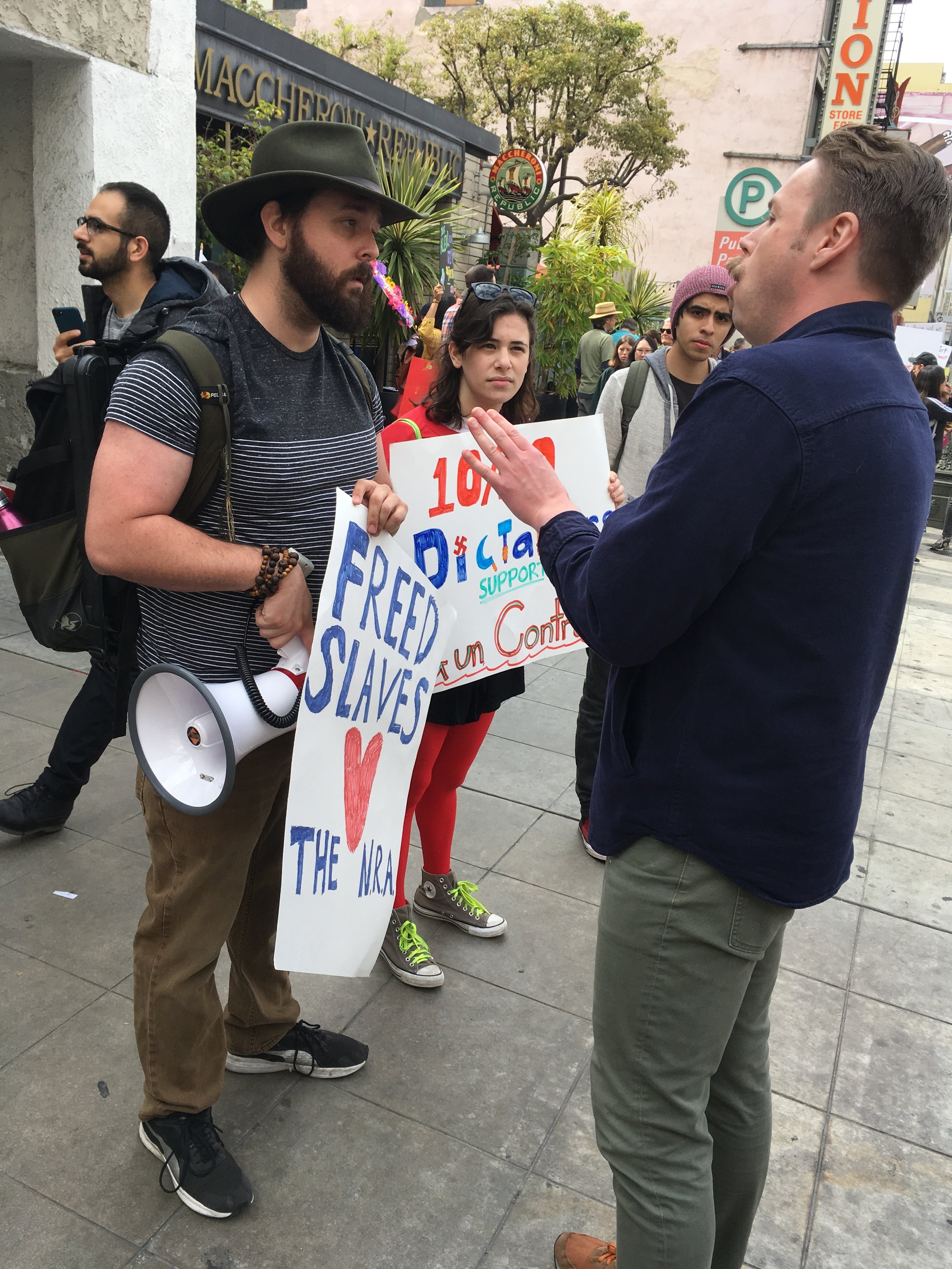  Santa Monica College student Ben Kolodny (left), with girlfriend Liberty Fuchs, debating with Spencer Thun about gun control. Kolodny didn't join the corner of counter-protestors at the March For Our Lives protest on March 24, 2018, in Los Angeles, 