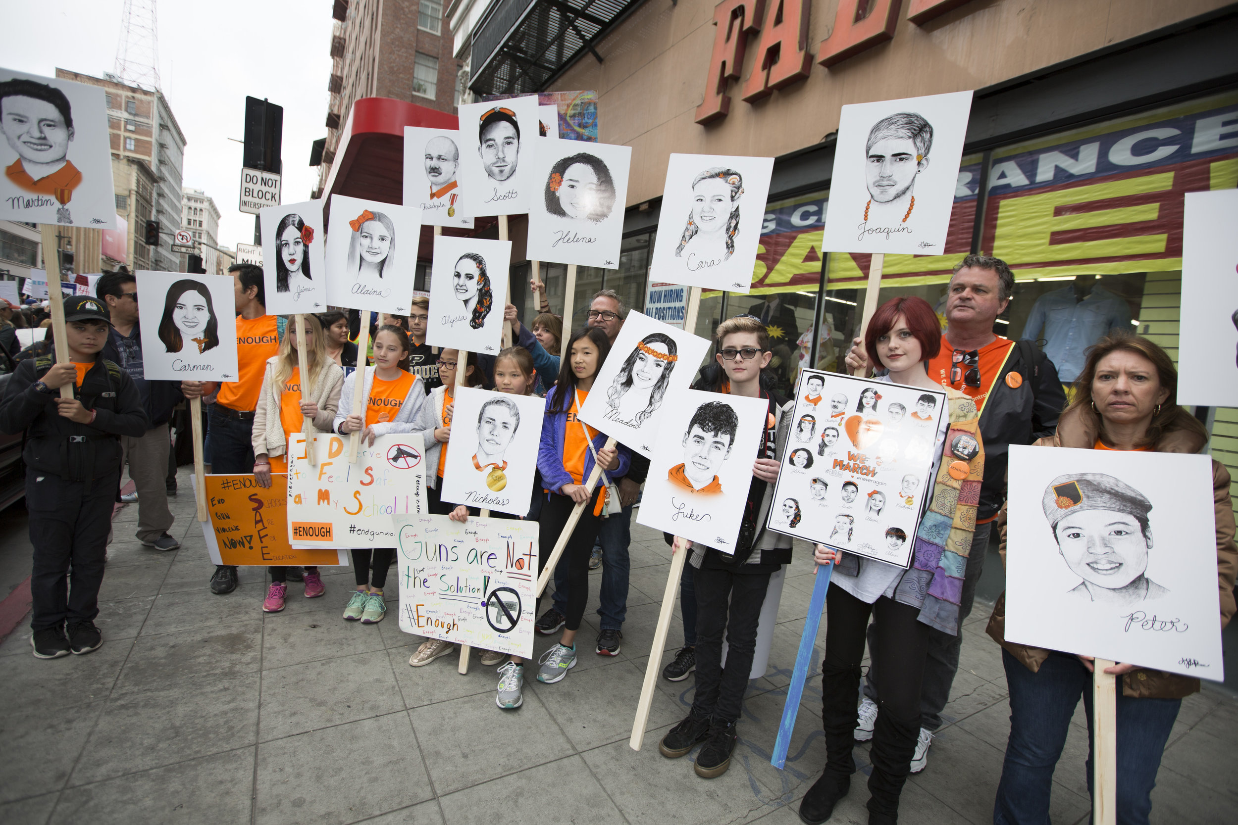  A group of young students, and parents, stand on 5th and Broadway in downtown Los Angeles holding art posters of the 14 fallen students from Majory Stoneman Douglas High School, before marching to City Hall during the March for Our Lives rally on Ma