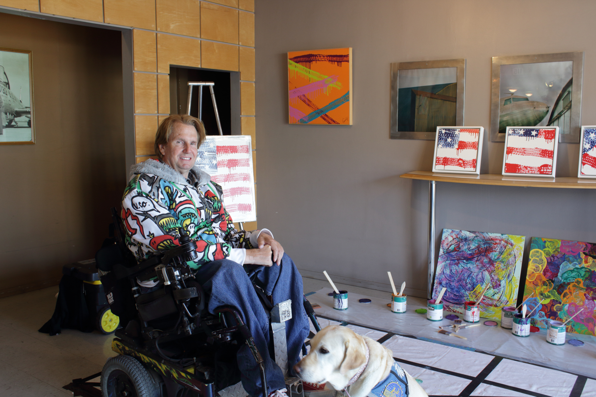  Tommy Hollenstein, wheelchair-bound quadriplegic artist, poses with his artwork made with the wheels of his wheelchair and service dog at the 12 Annual Santa Monica ArtWalk on March 24th, 2018 in Santa Monica, California. (Heather Creamer/ Corsair P